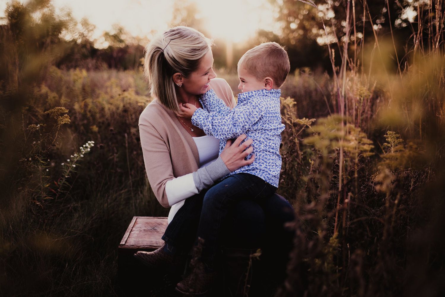 A sweet interaction between parent and child outdoors in warm autumn light.