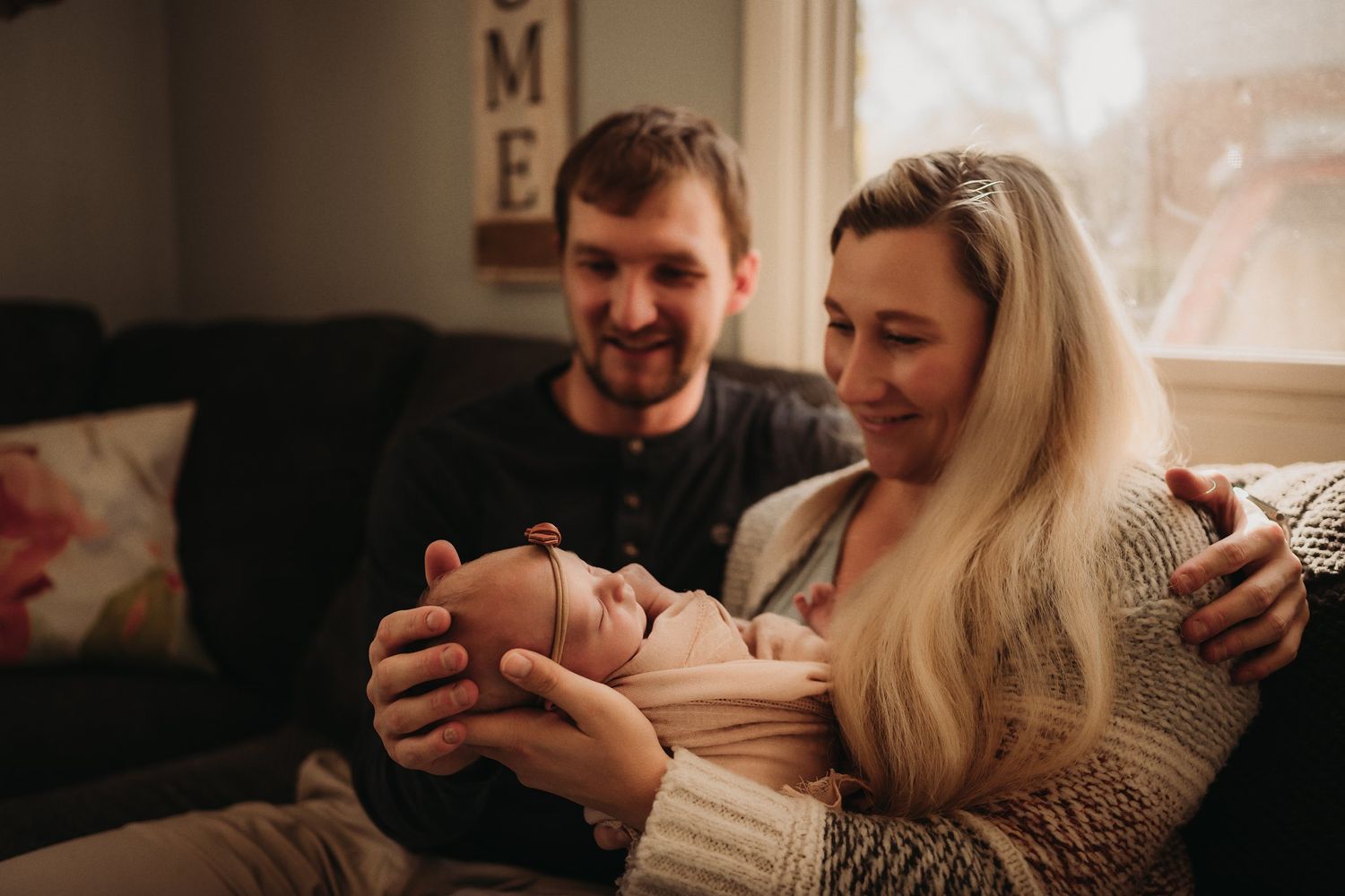 A cozy indoor scene of a family sharing tender moments on their living room sofa.