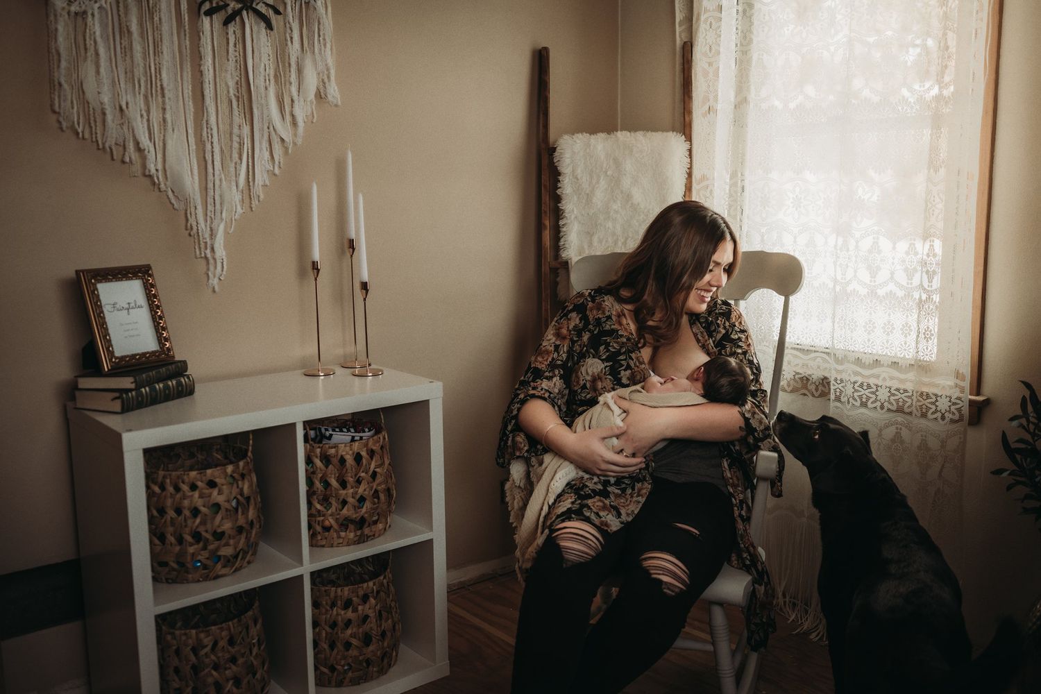 Intimate nursery moment with dog watching beside storage cube shelving and macrame wall art.