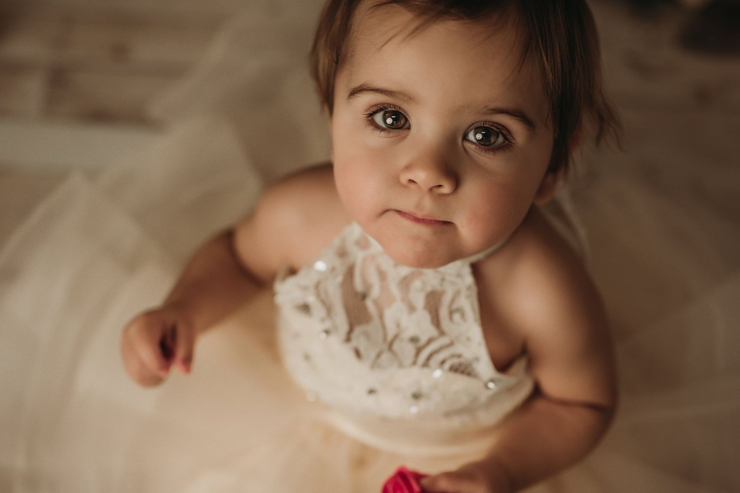 A close-up portrait showcases delicate lace details on a cream-colored dress.