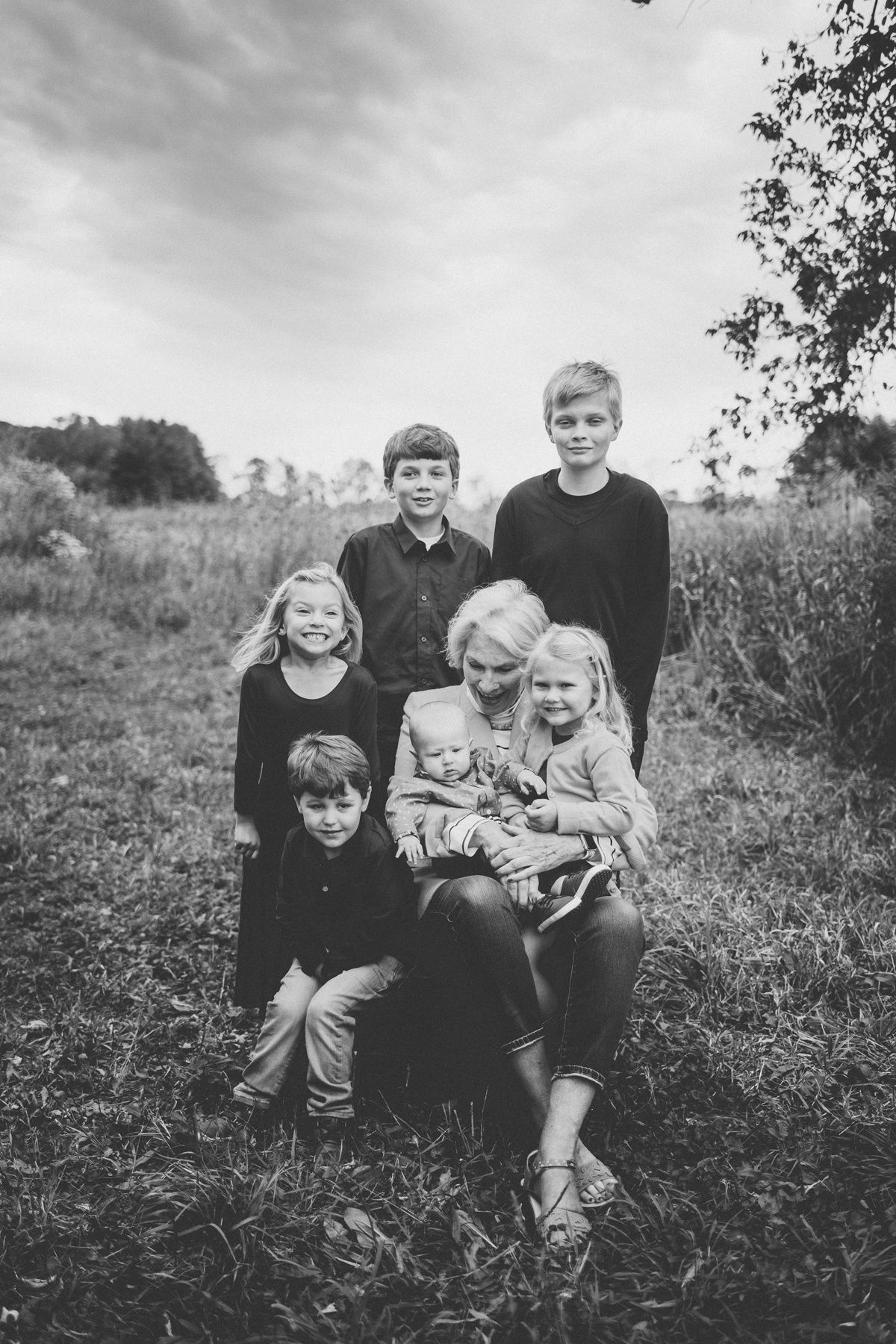 Black and white family portrait in a natural meadow setting.