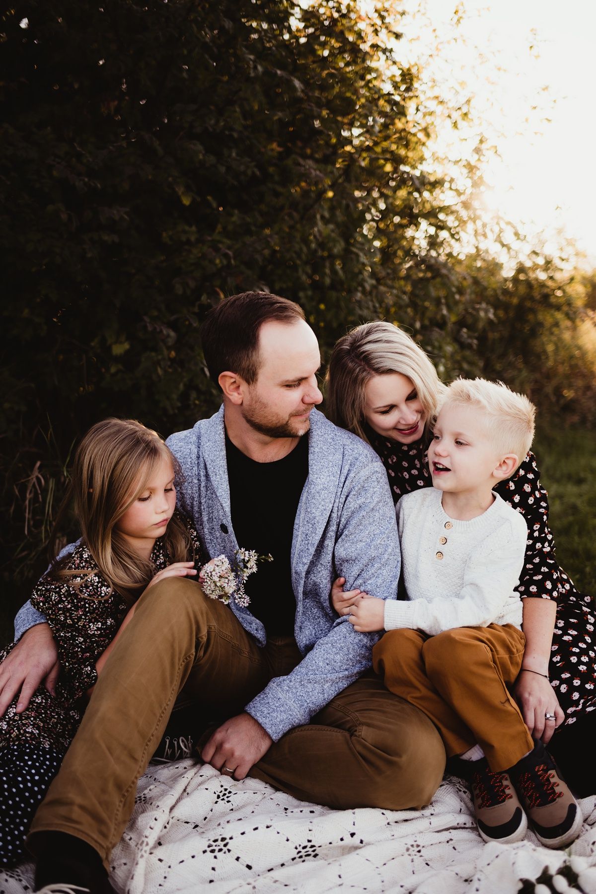 An intimate family portrait session outdoors during golden hour with natural poses.