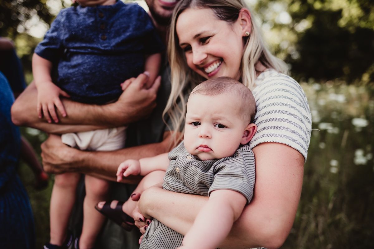 Casual outdoor family moment with small children in natural lighting.