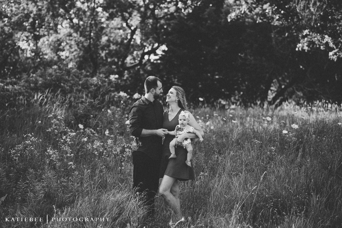 Black and white portrait of family members in a meadow.