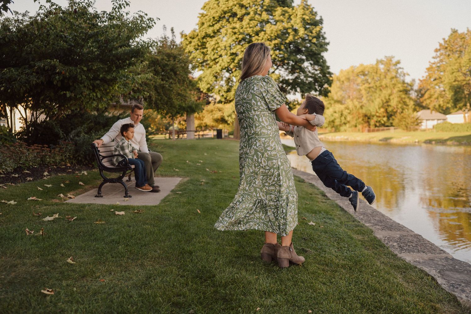 Series of casual outdoor family portraits captured along scenic waterfront path at sunset.