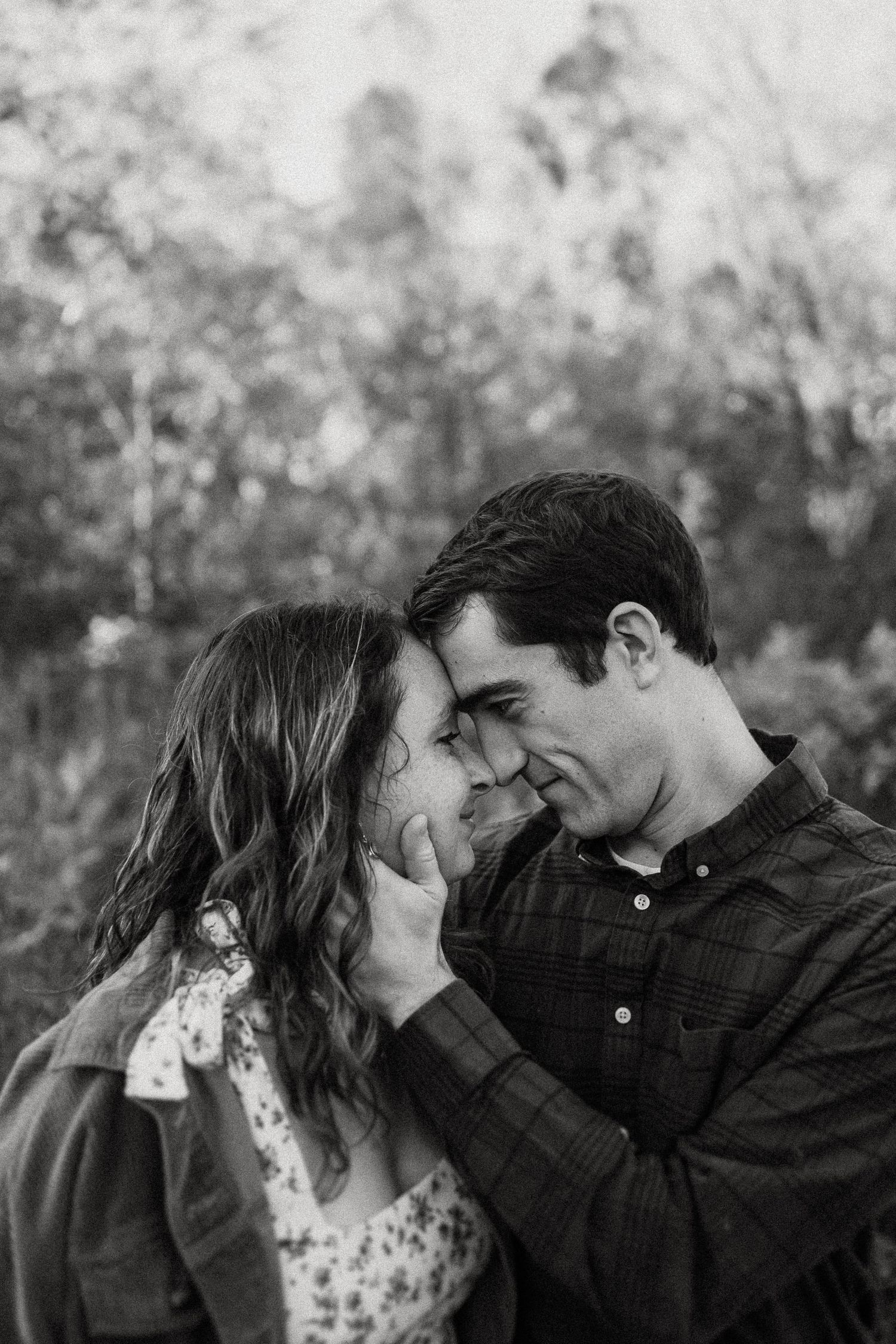 Black and white close up of tender moment between couple outdoors.