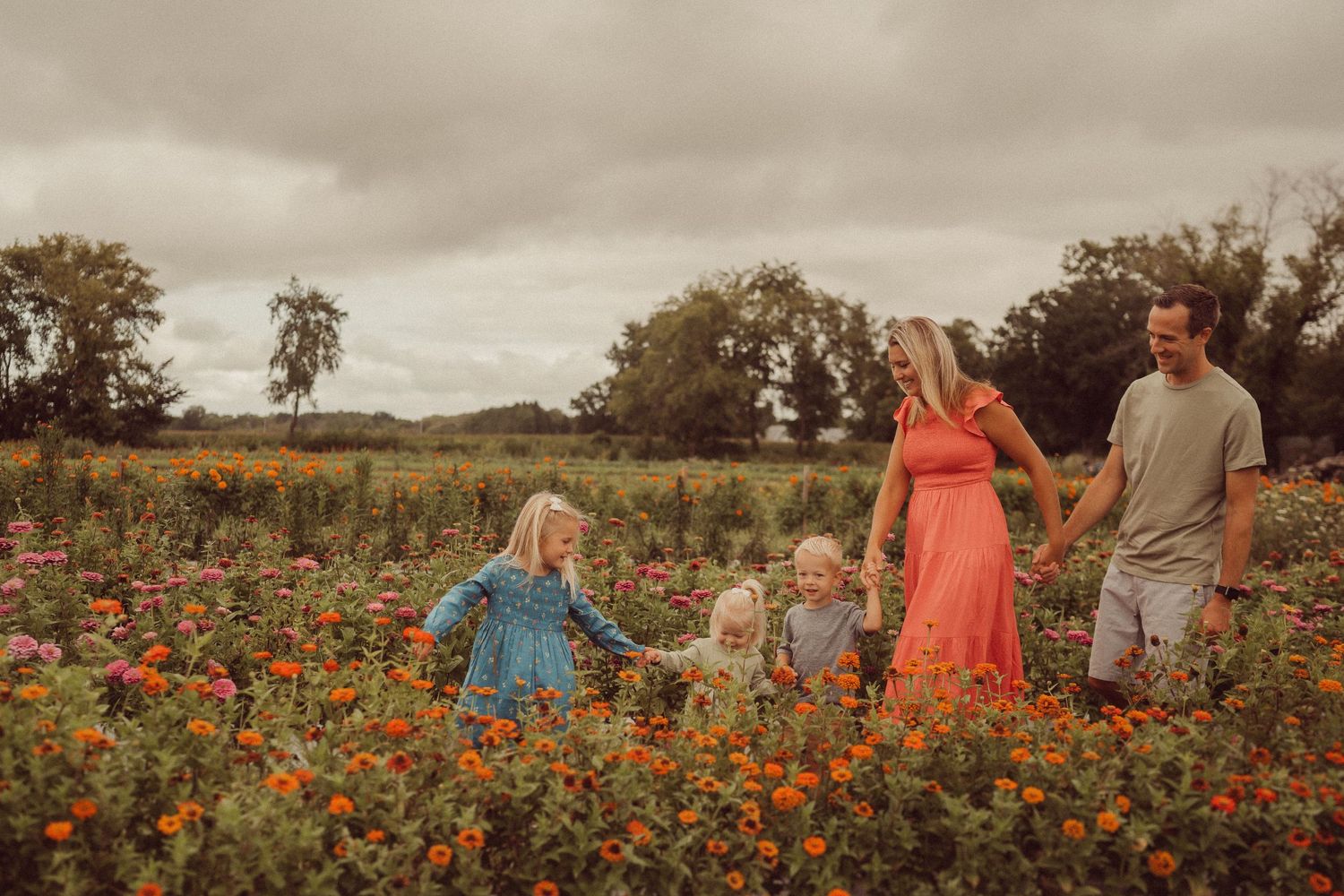 Family enjoying time together in a blooming wildflower field during golden hour.