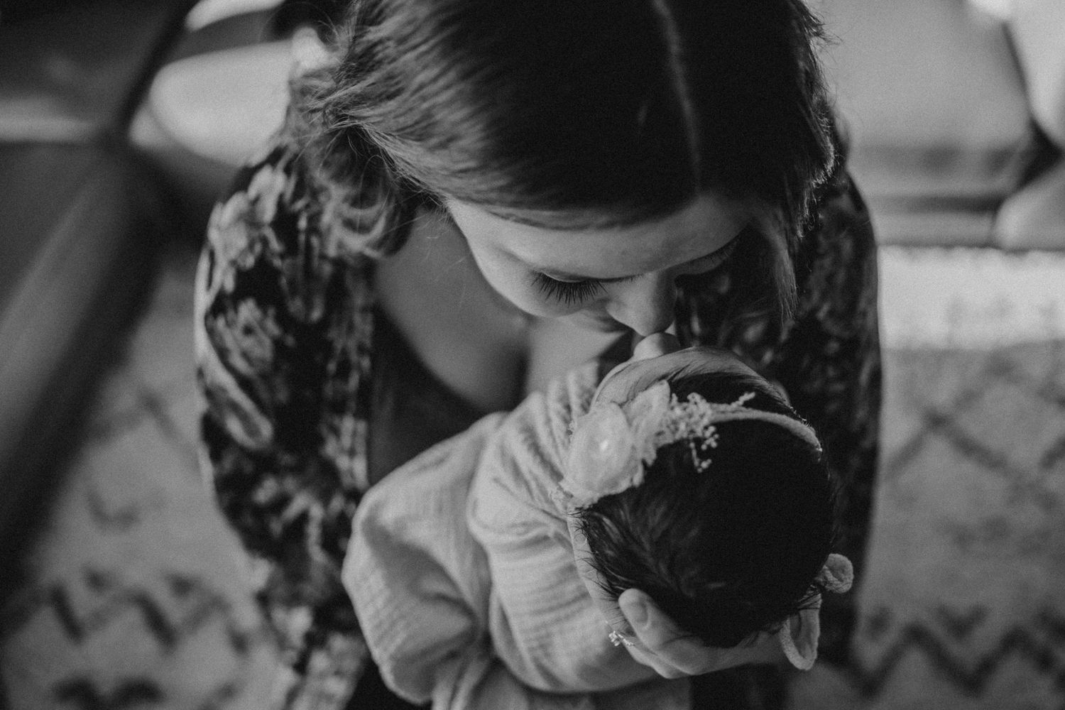 Overhead black and white shot of gentle moment with sleeping infant.