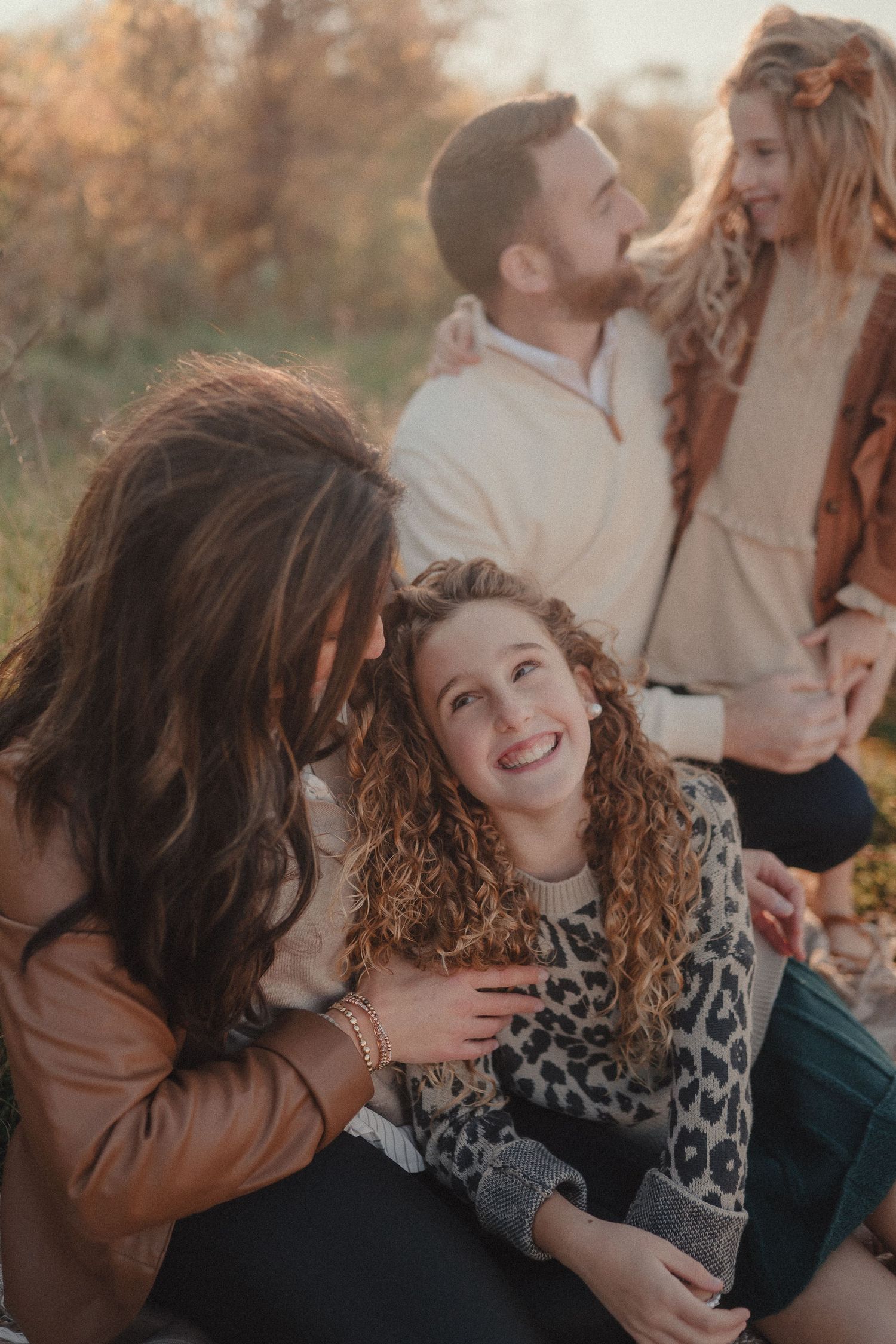 Candid moments of affection captured during a fall photoshoot outdoors.