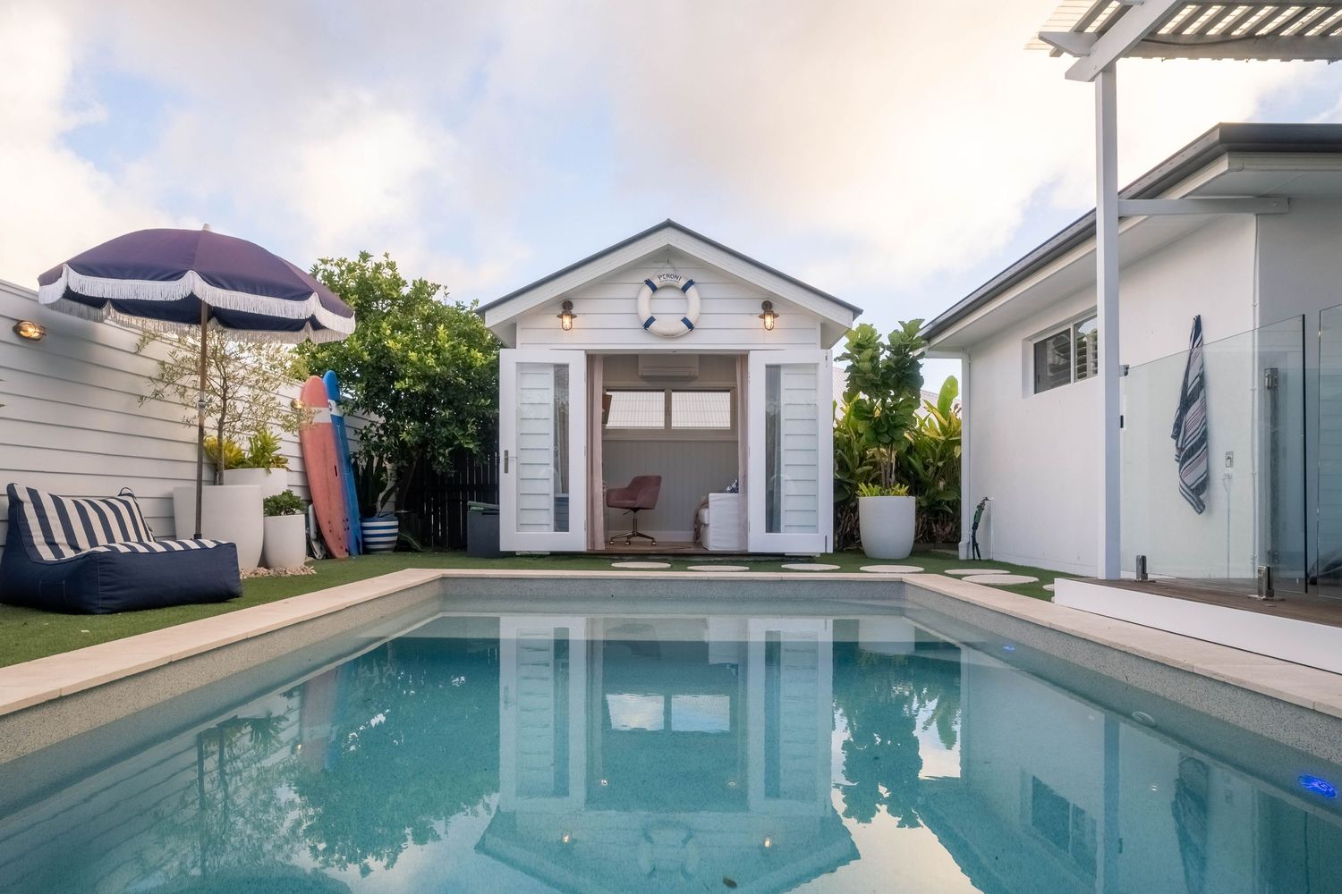 Sunshine Coast real estate photography: luxury swimming pool and white nautical pool house studio with premium coastal lifestyle styling