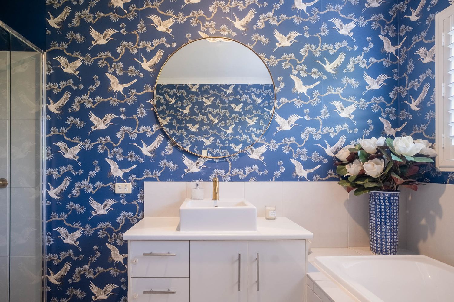 Sunshine Coast real estate photography: modern bathroom featuring luxury blue crane wallpaper, gold mirror, and premium interior styling.