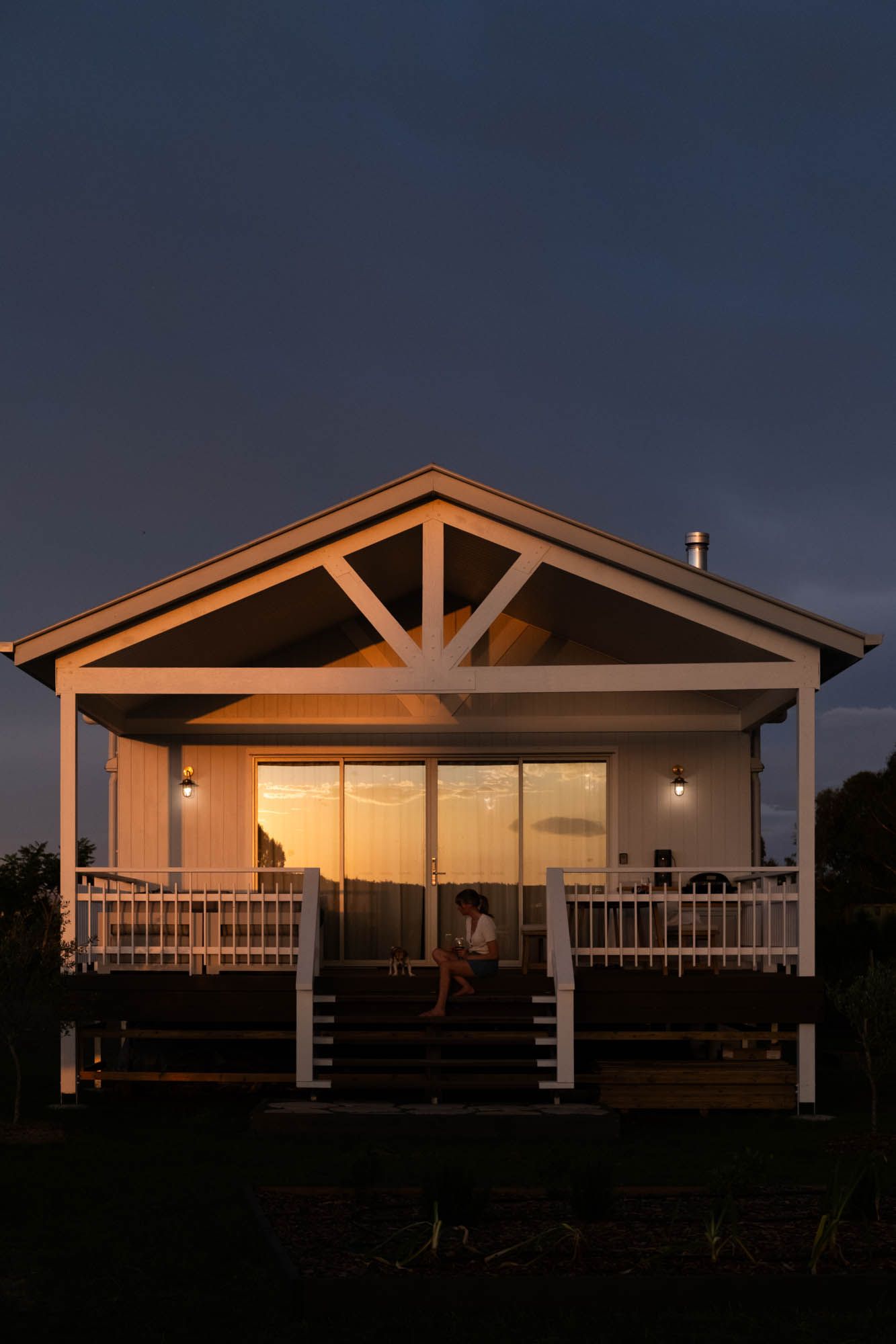 Professional twilight real estate photography of a modern cabin on the Sunshine Coast, featuring golden hour reflections and a gabled porch