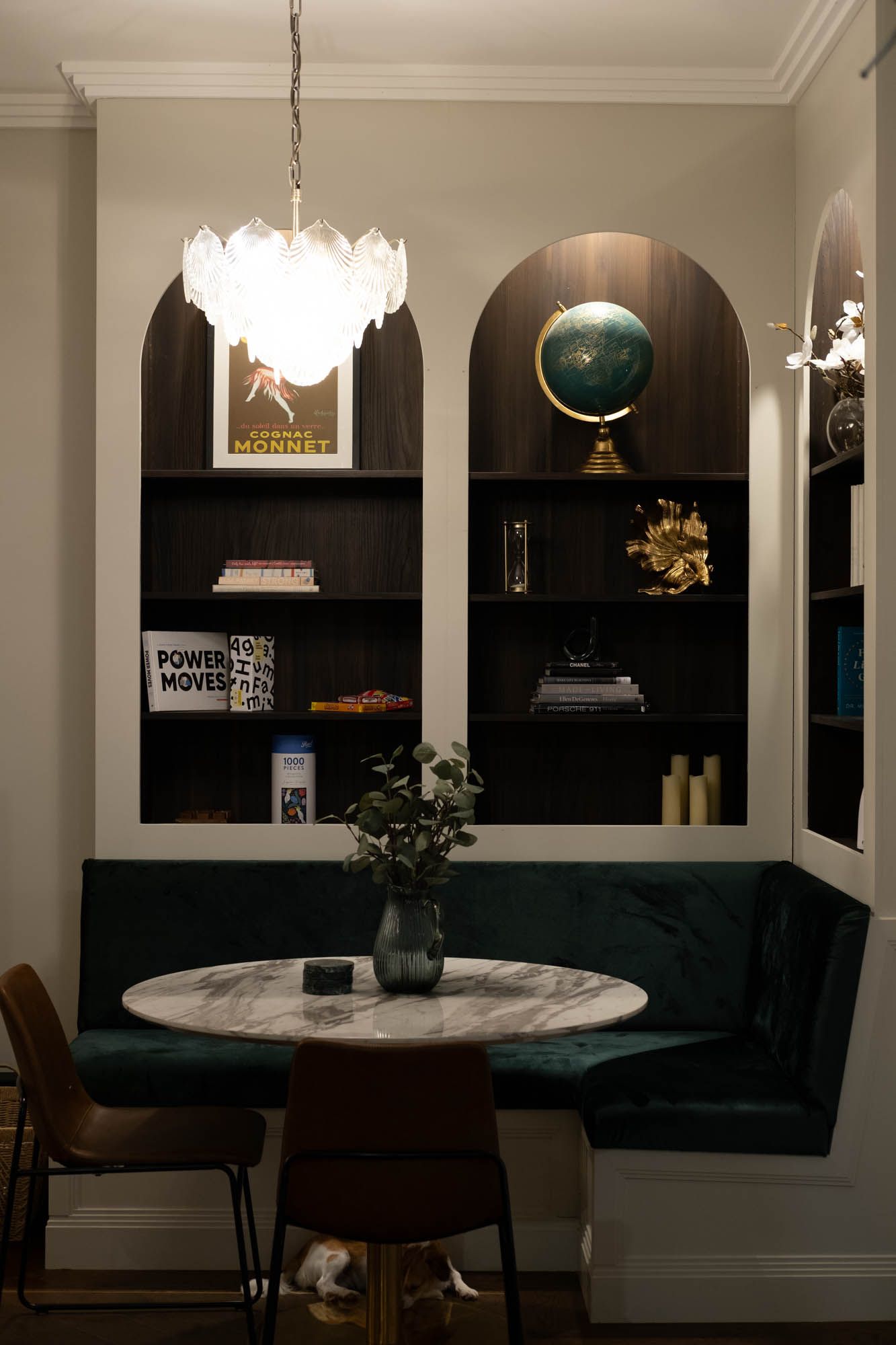 Sunshine Coast real estate photography: luxury dining nook with velvet banquette seating, marble table, and arched architectural shelving