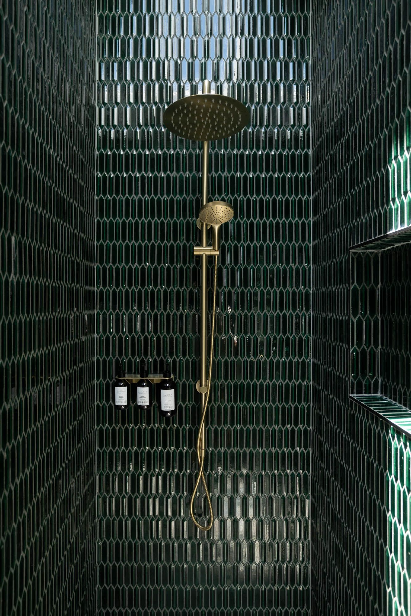 Sunshine Coast real estate photography, luxury dark green picket tile shower featuring gold rain shower head and integrated wall niche