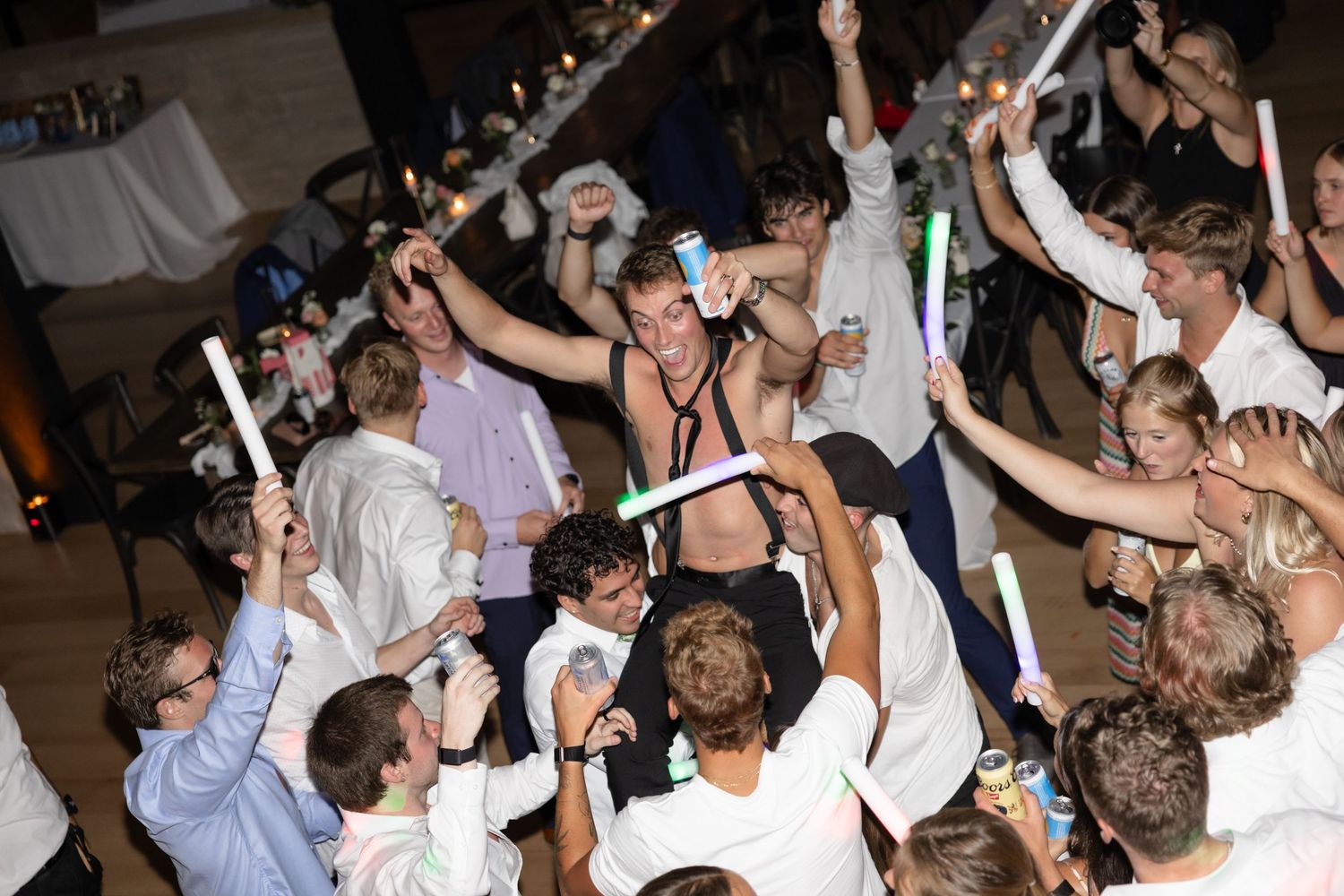 Crowded dance floor with guests celebrating at a wedding reception.