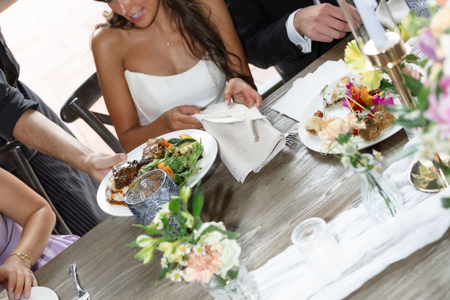 Wedding guests enjoying a formal dinner reception at elegantly decorated tables.
