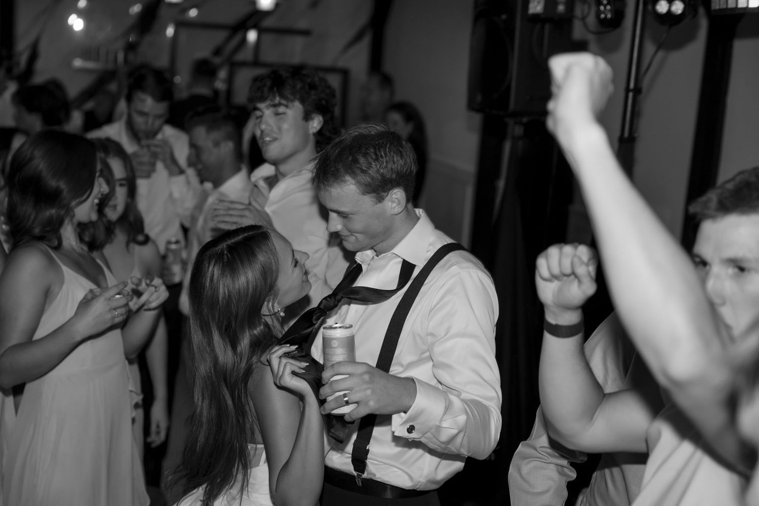 People dancing and celebrating at a lively wedding reception party.