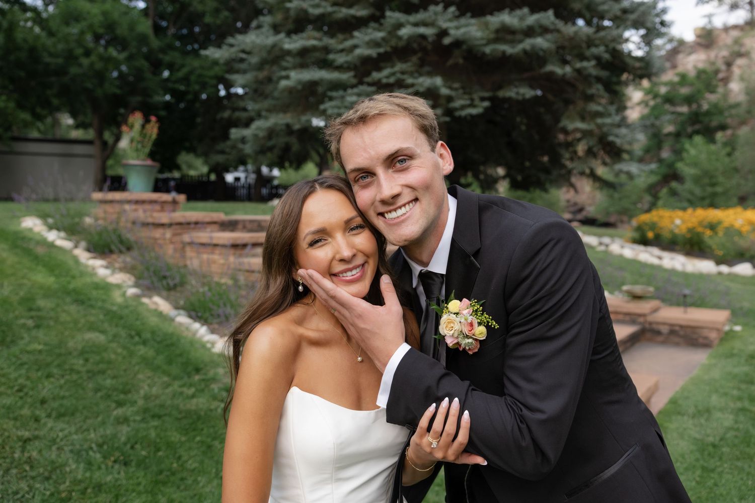 Happy couple shares candid moments during their wedding photoshoot in a scenic outdoor setting.