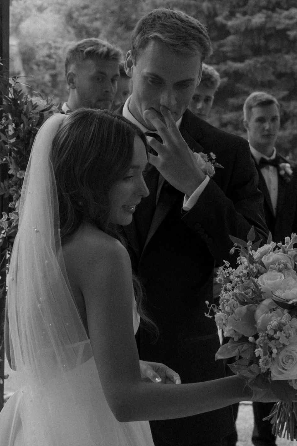 Black and white artistic wedding ceremony photos showing intimate moments between the couple during their nuptials.