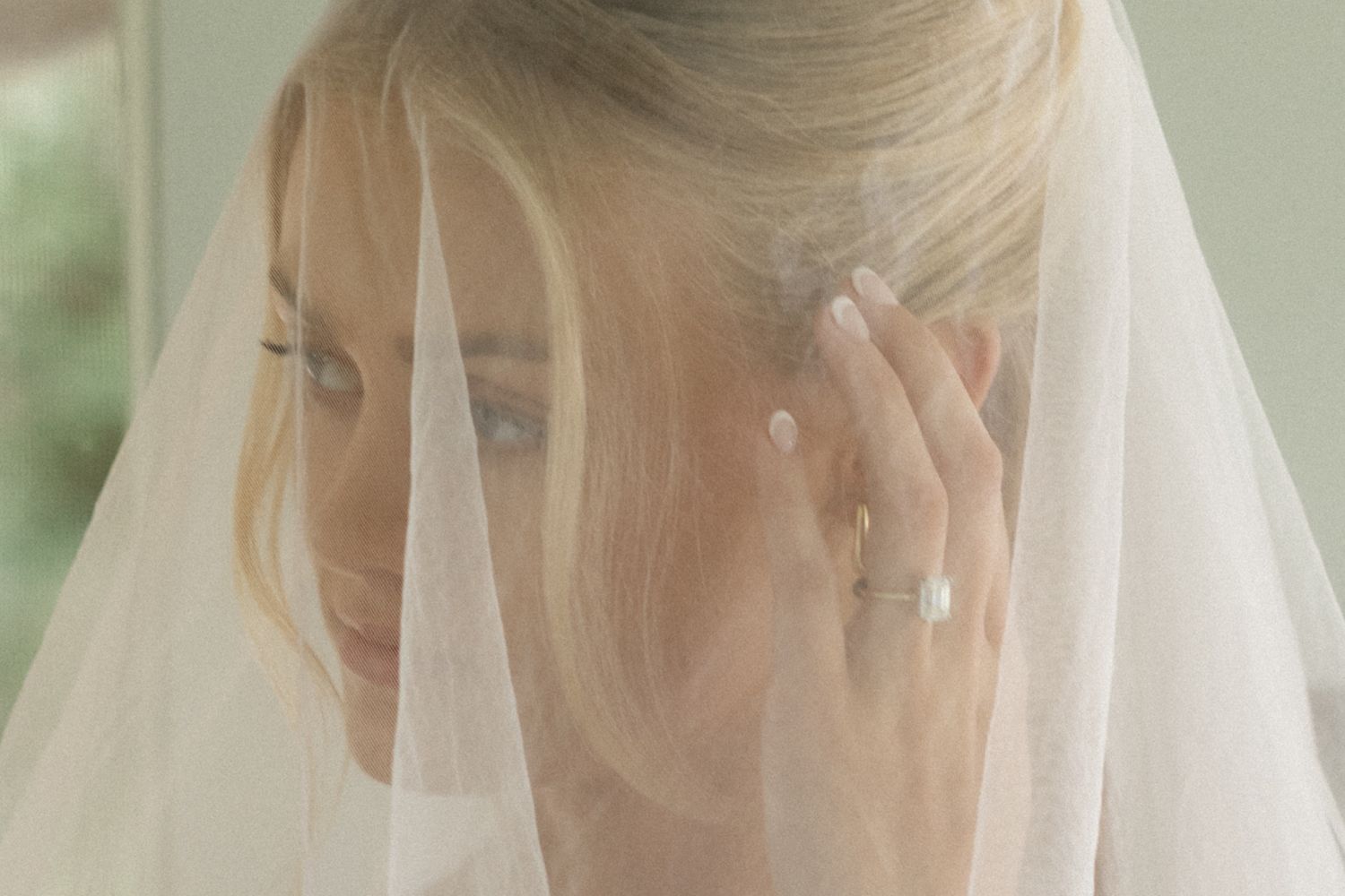 Delicate white bridal veil detail against a soft, natural background.
