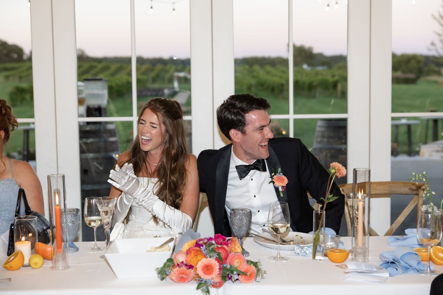 Wedding reception dining tables set with elegant place settings in a bright sunlit venue.