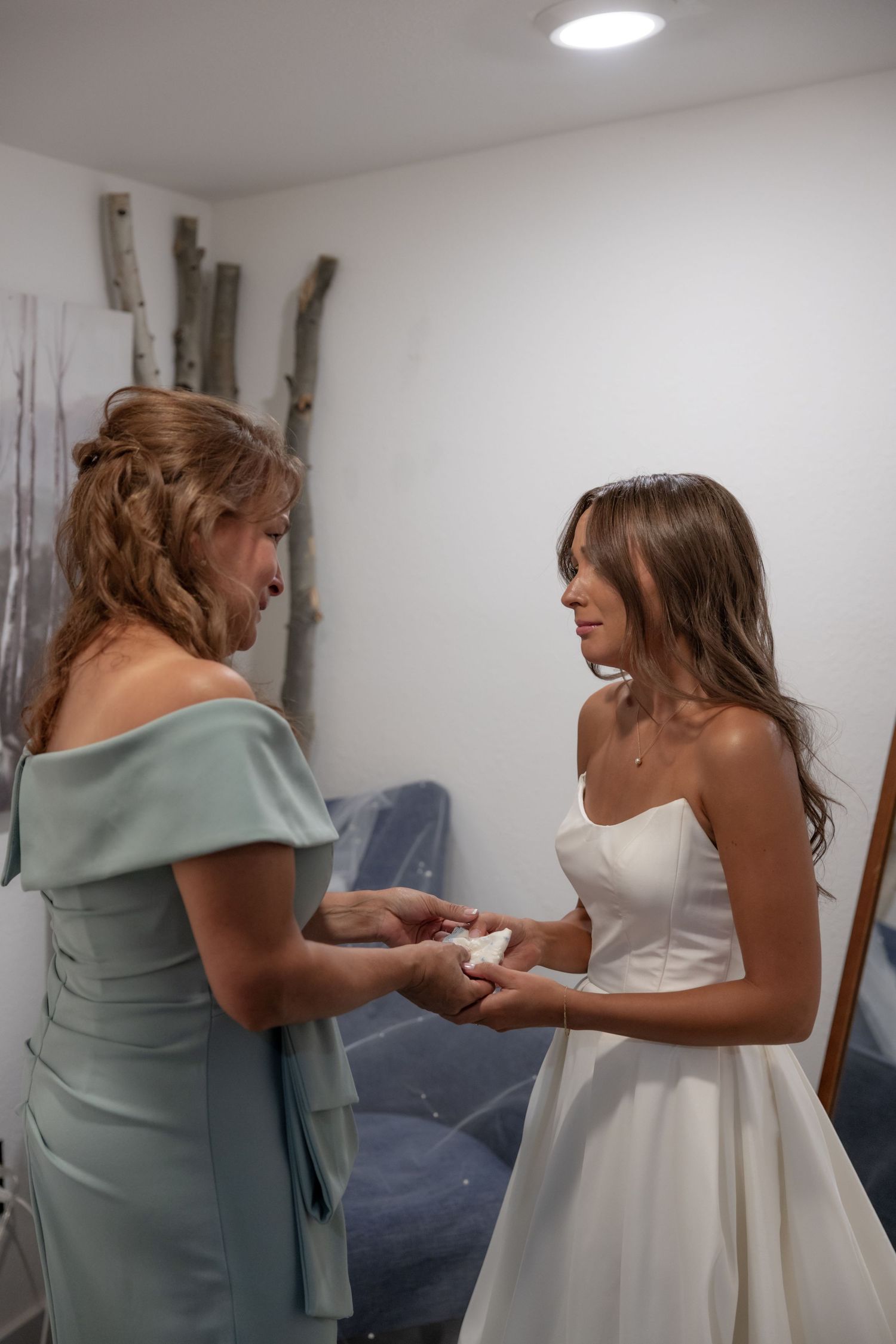 Two people in formal attire share an emotional moment in a getting ready room.