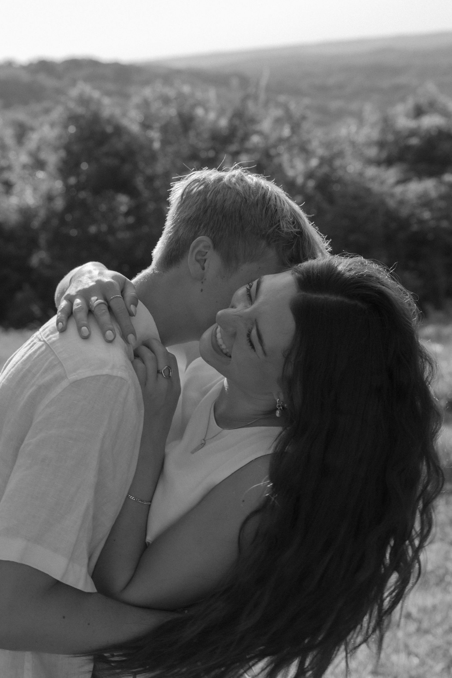 A series of intimate close-up moments between a couple against a natural landscape.