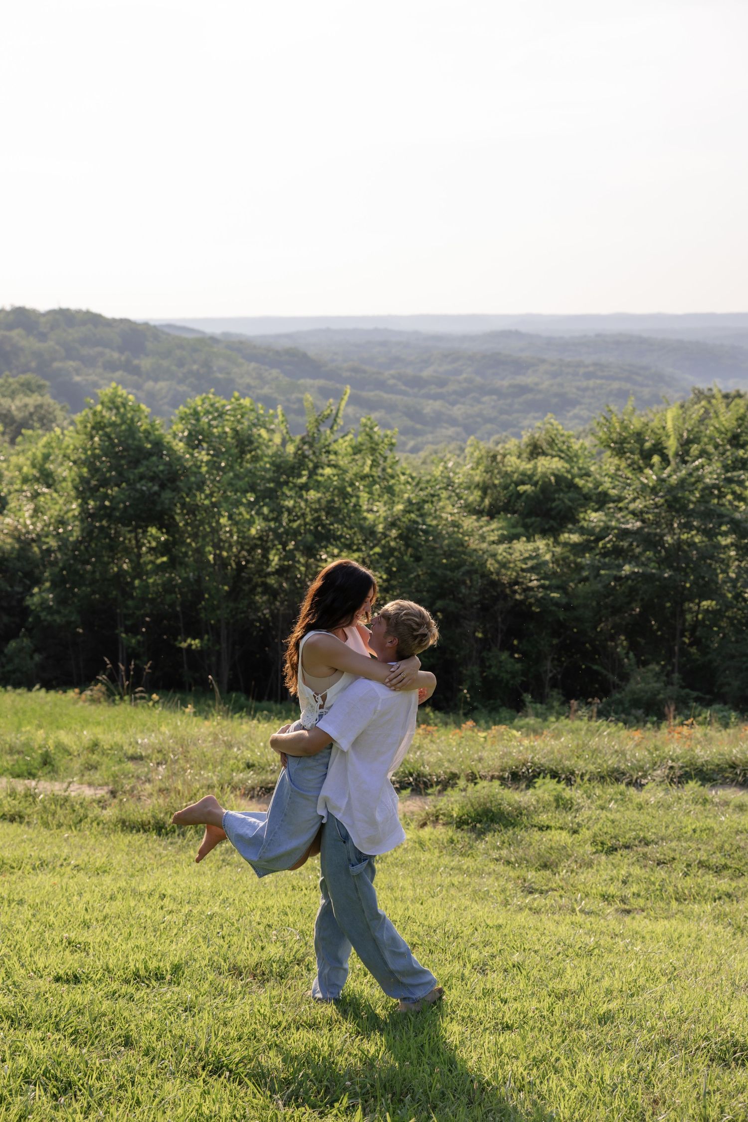 A romantic sequence of playful spinning and lifting moments in a sunlit meadow.