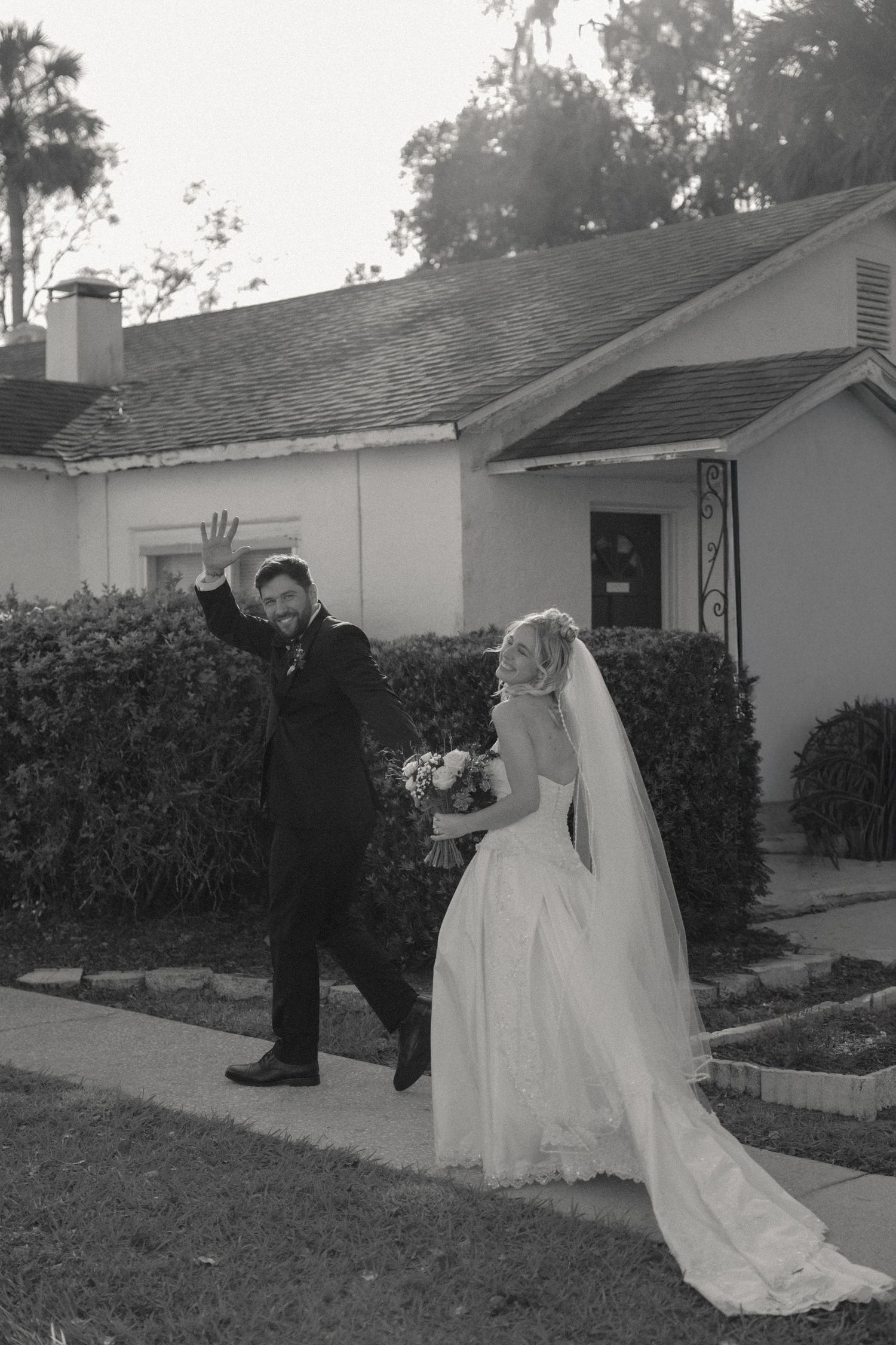 Black and white wedding first look sequence showing moments between bride and groom outside a house.