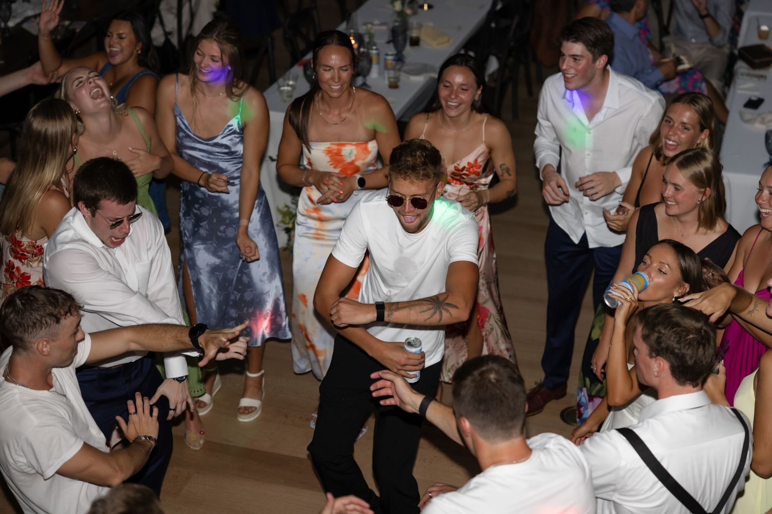 Crowded dance floor with party guests celebrating at a wedding reception.