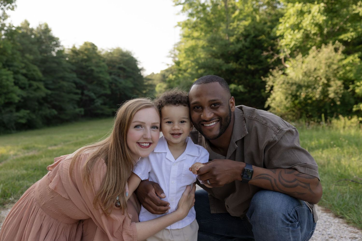 Happy family shares laughs while posing together on an outdoor path.