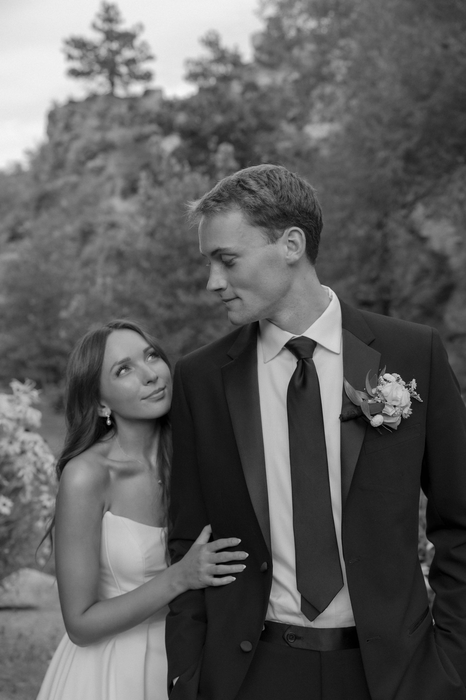 An intimate black and white portrait of newlyweds against a mountainous landscape.