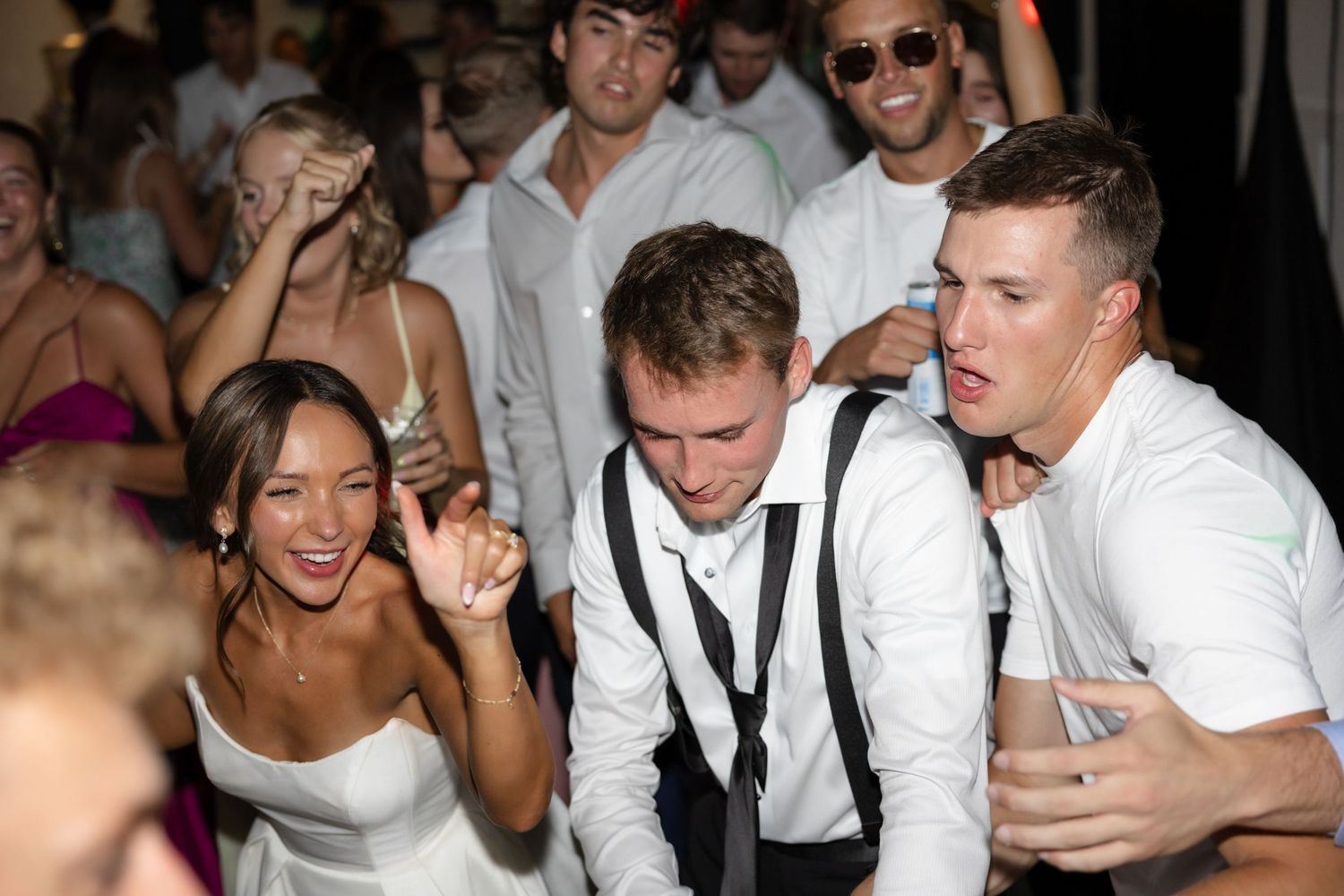 Wedding guests socializing and dancing at an indoor reception venue.