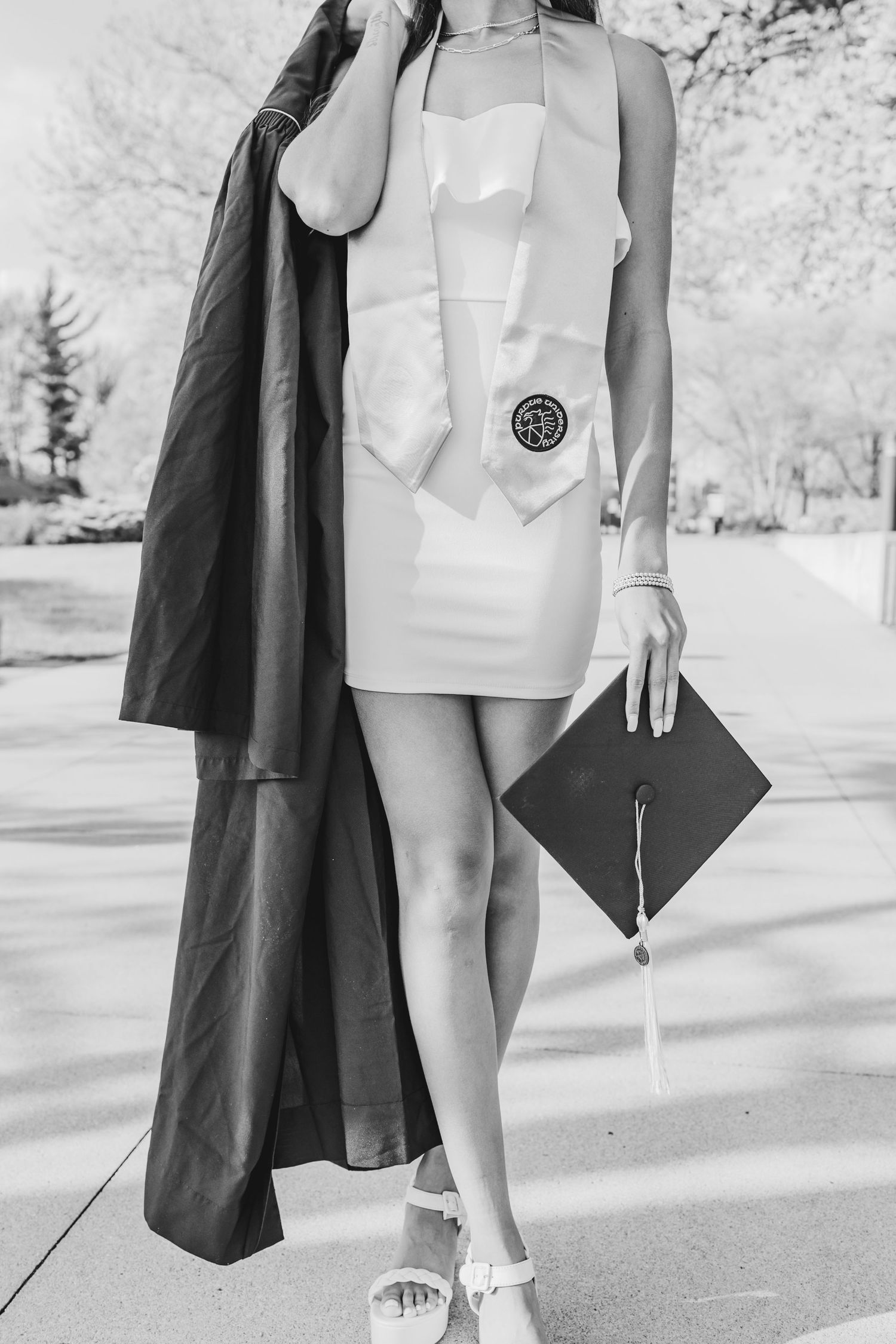 Black and white graduation photo showcasing cap and gown details.