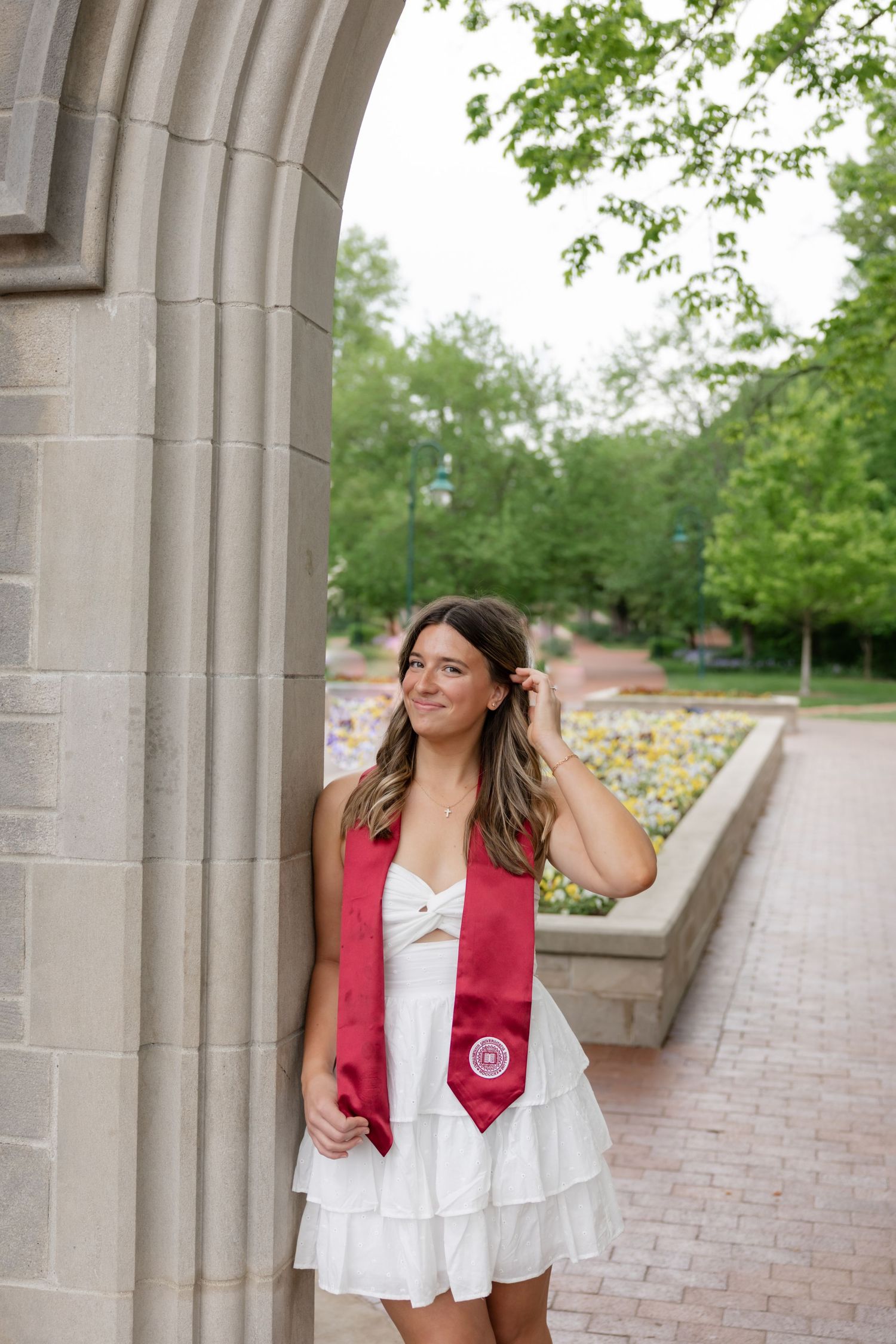 Stone archway entrance on a college campus with brick pathways and landscaping.
