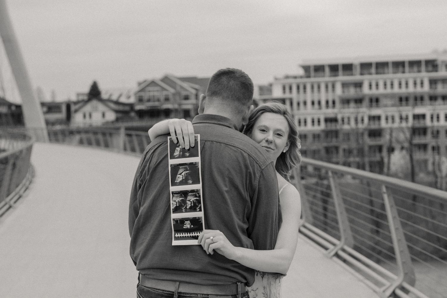 Side view of couple sharing tender moment during bridge maternity photoshoot.