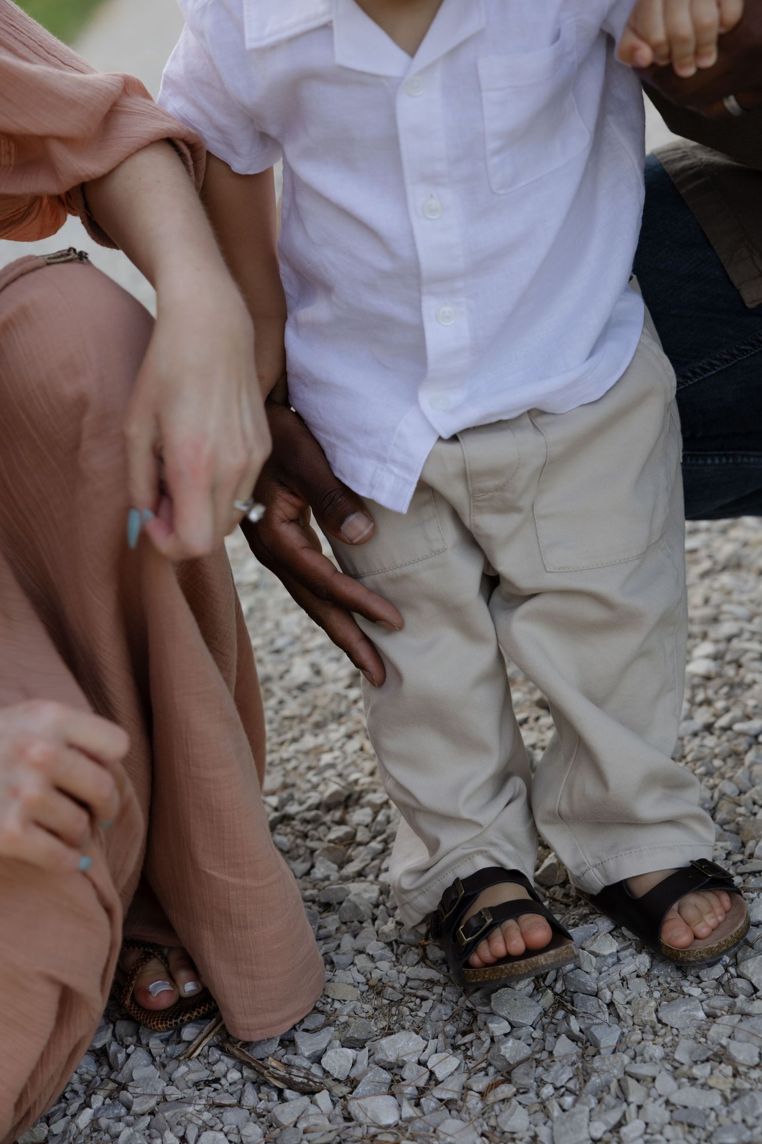 Close-up shot of feet walking together on a gravel path.