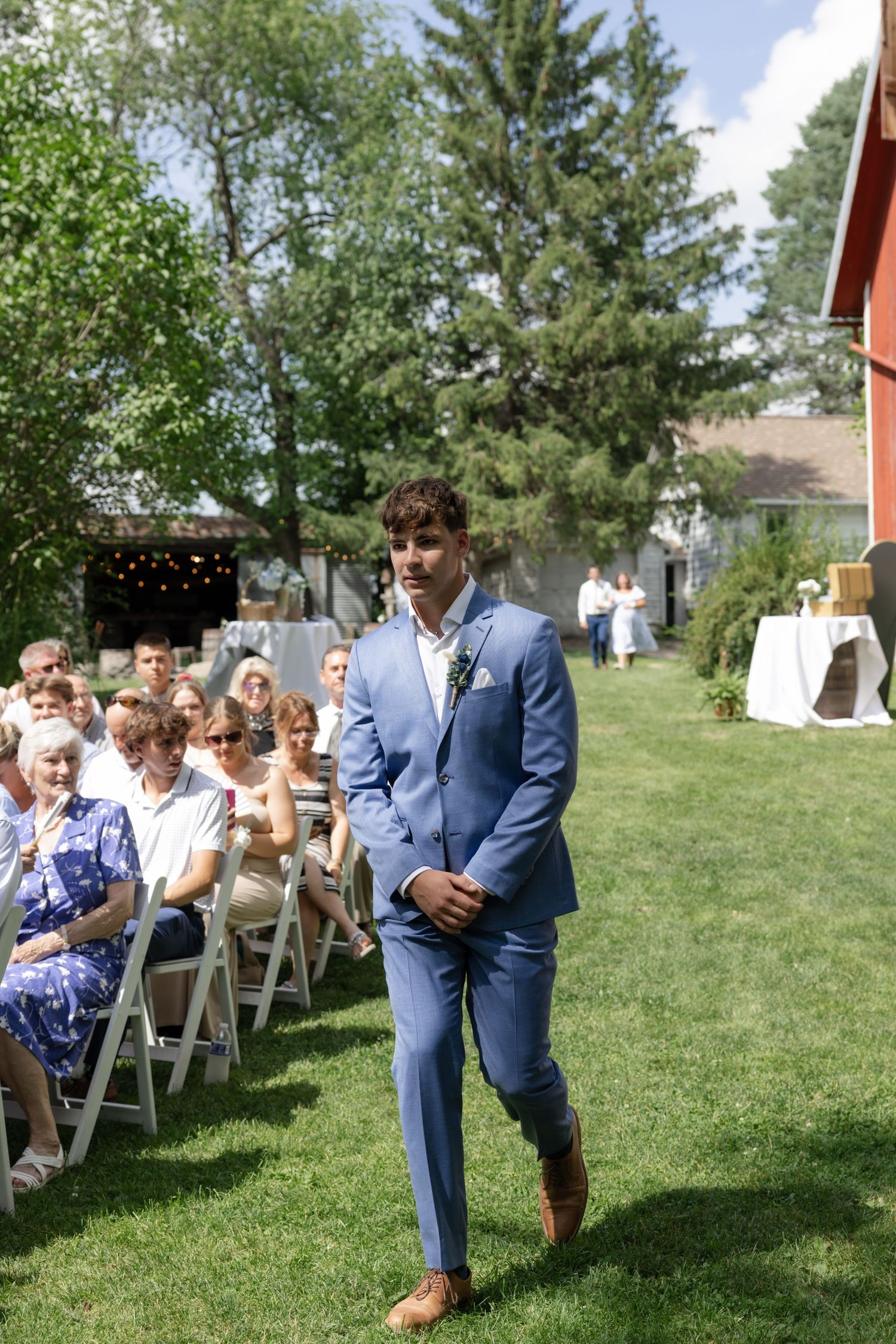 Wedding ceremony seating arranged on green lawn with white folding chairs.