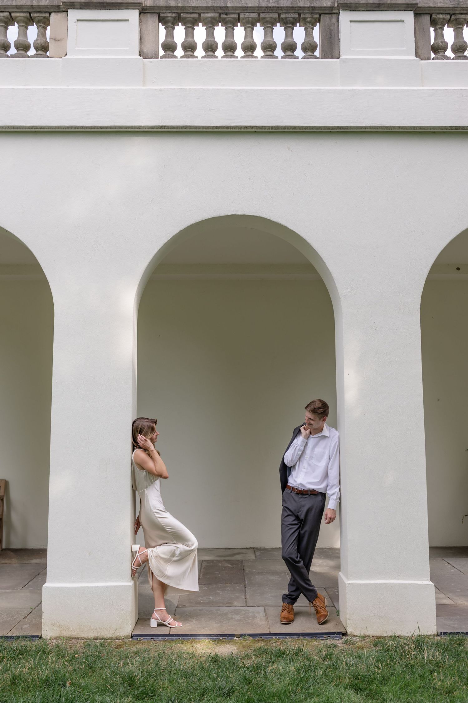 Creative portrait using white mansion archways and columns as architectural framing elements.