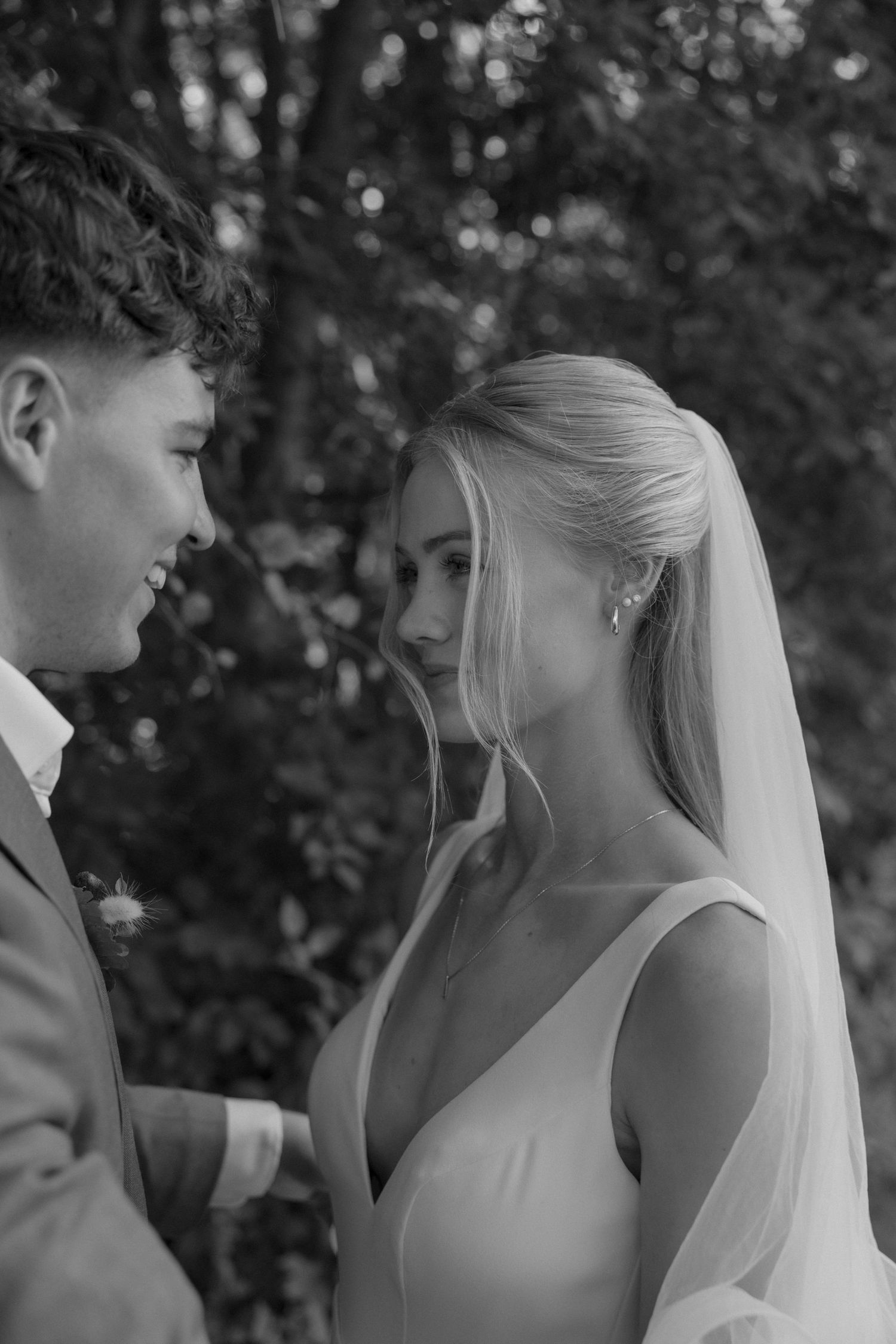 Intimate black and white wedding portrait capturing a tender moment between newlyweds.