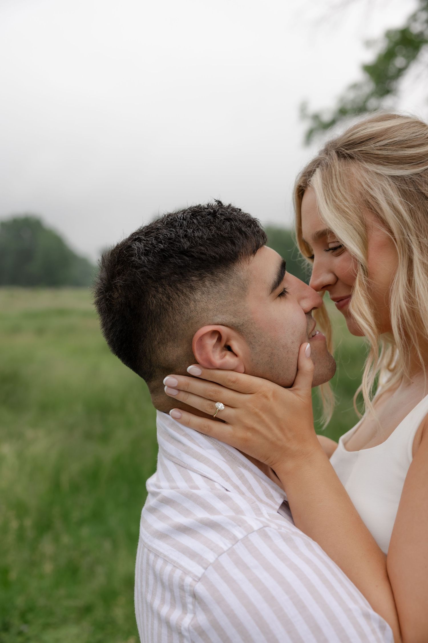 Romantic couple shares tender moments in outdoor wedding photoshoot.