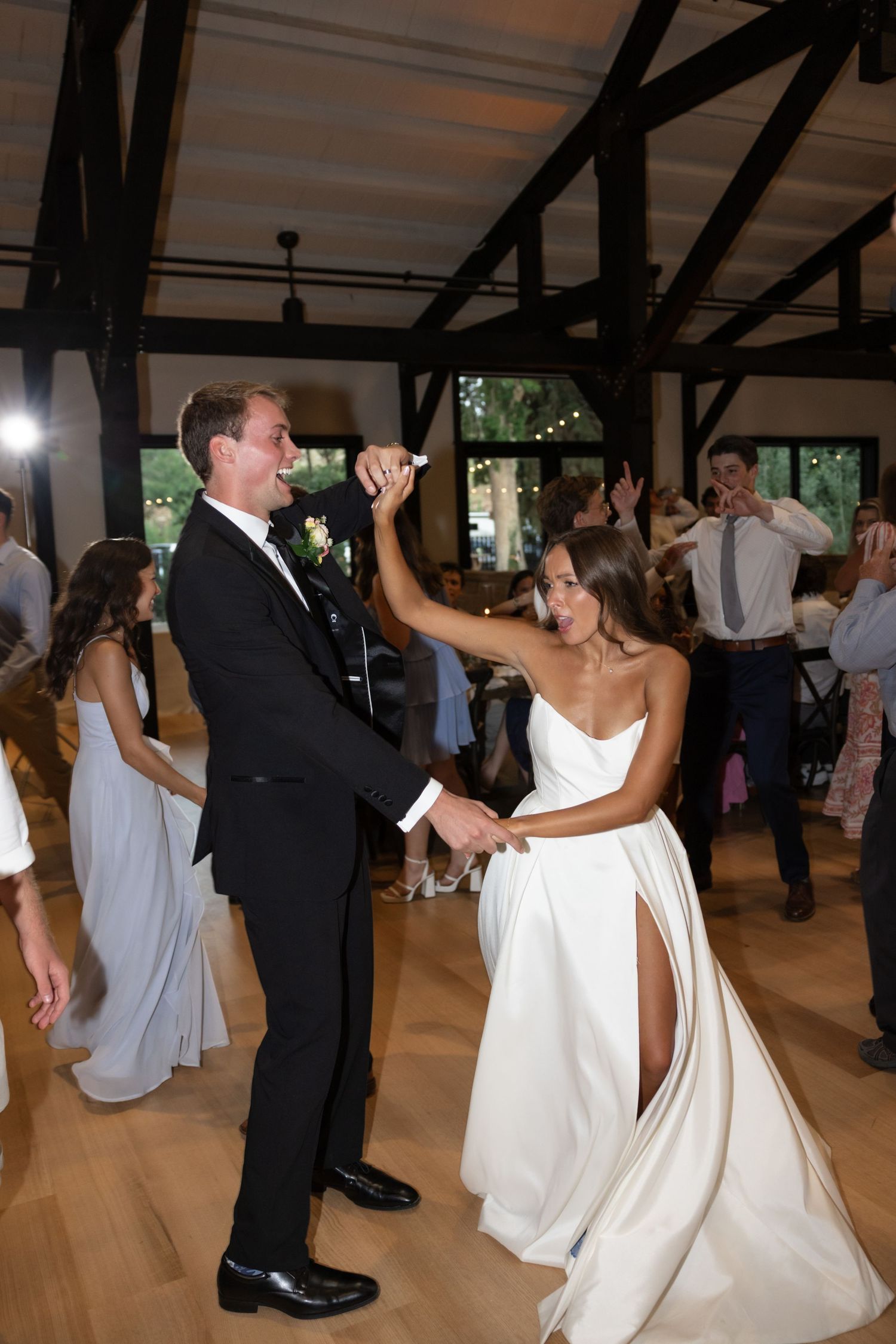 Couple performs an energetic dance move during their wedding reception.
