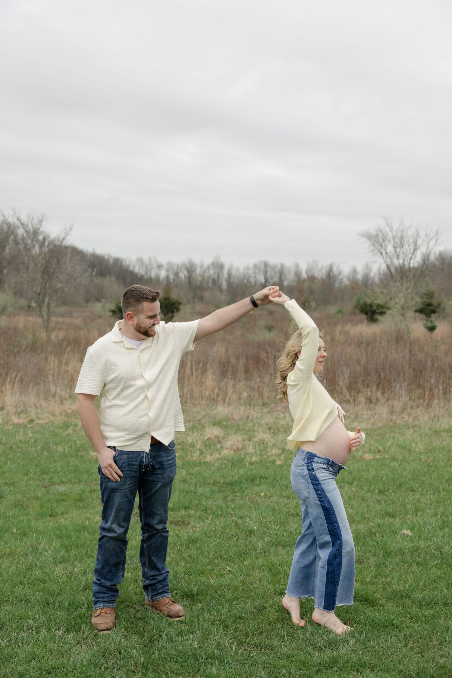 A playful maternity photoshoot sequence captured in a grassy field on an overcast day.
