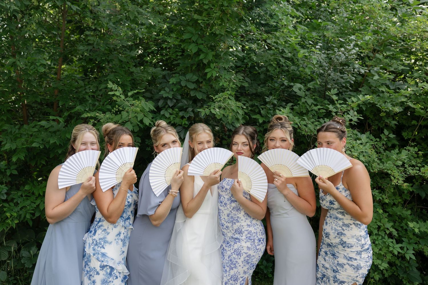 Wedding party having fun posing for playful photos outdoors.
