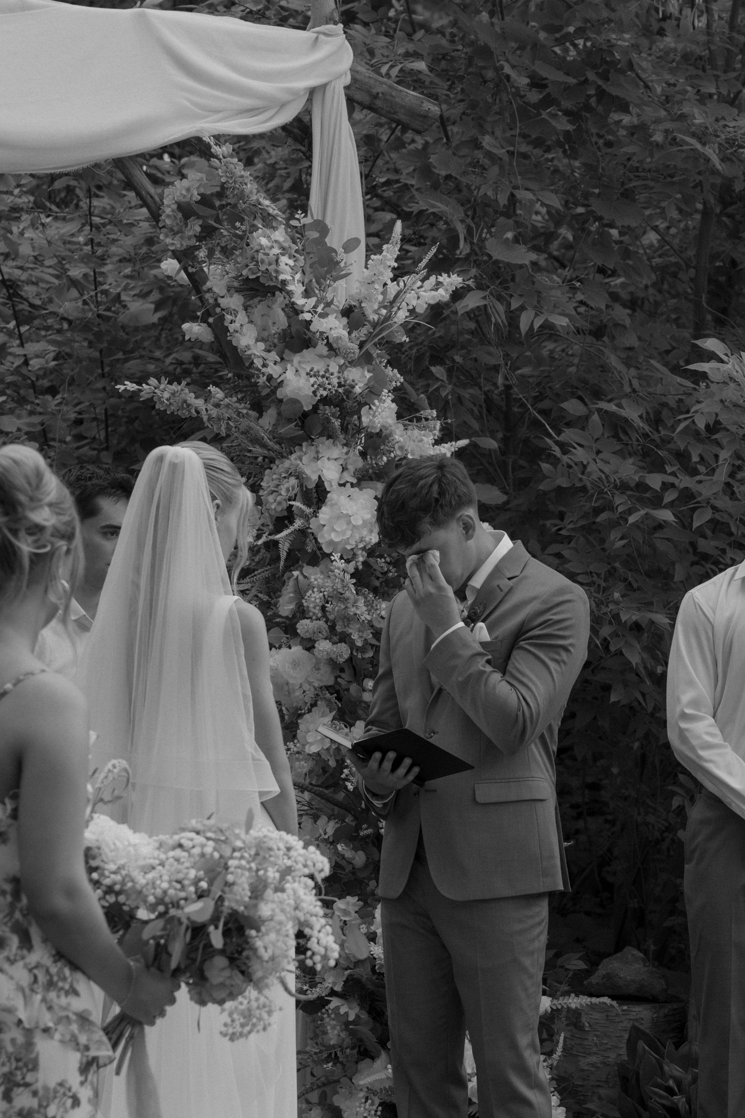 An intimate outdoor wedding ceremony moment captured in black and white.