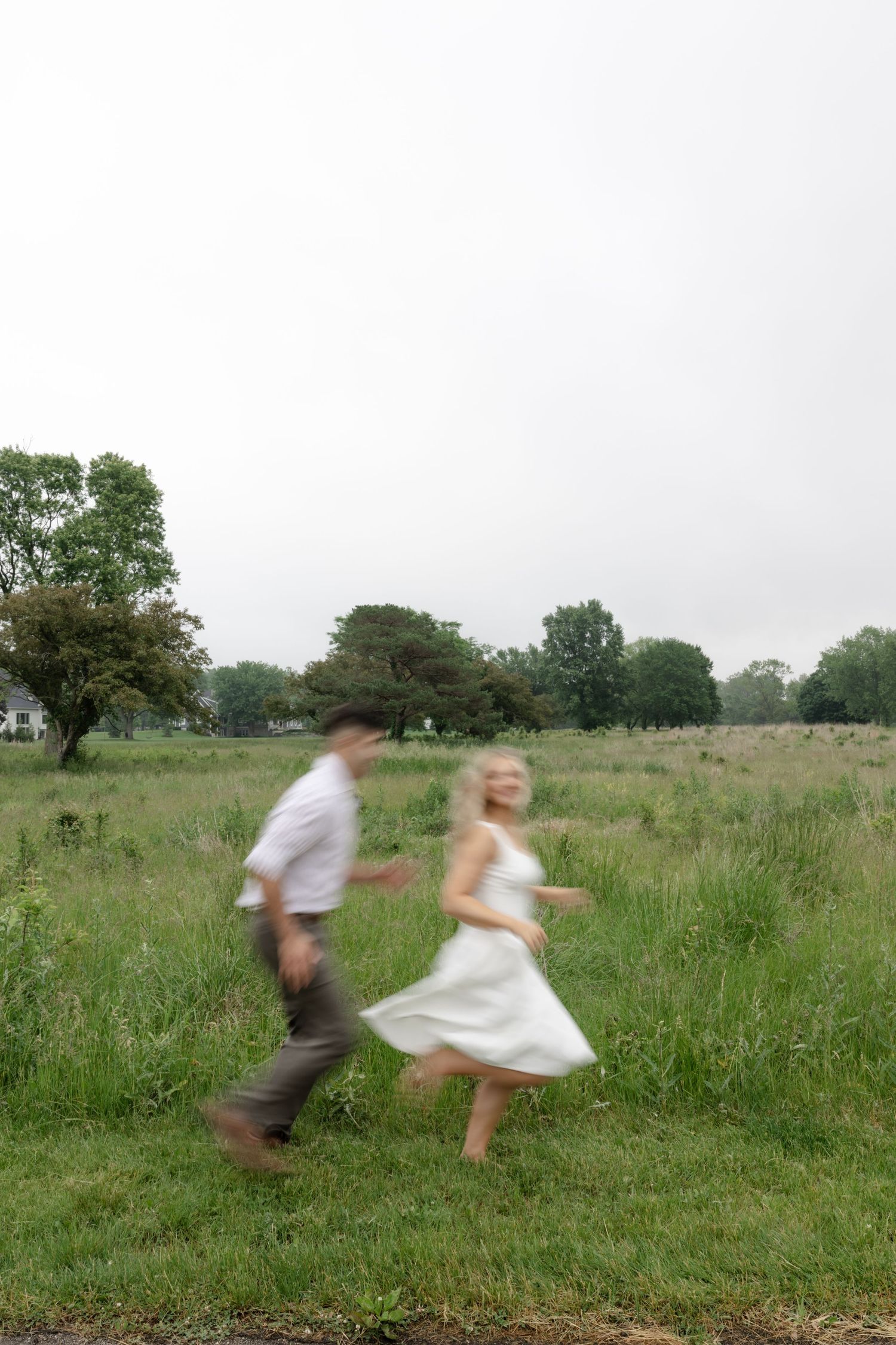 A playful sequence of a couple running and spinning in a green summer meadow.