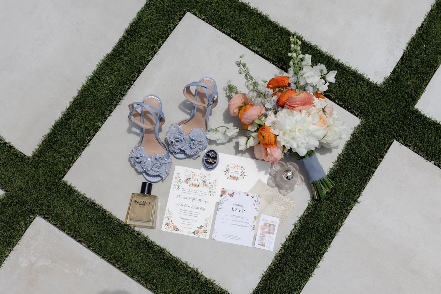 Wedding details and decorations arranged on artificial grass surface.