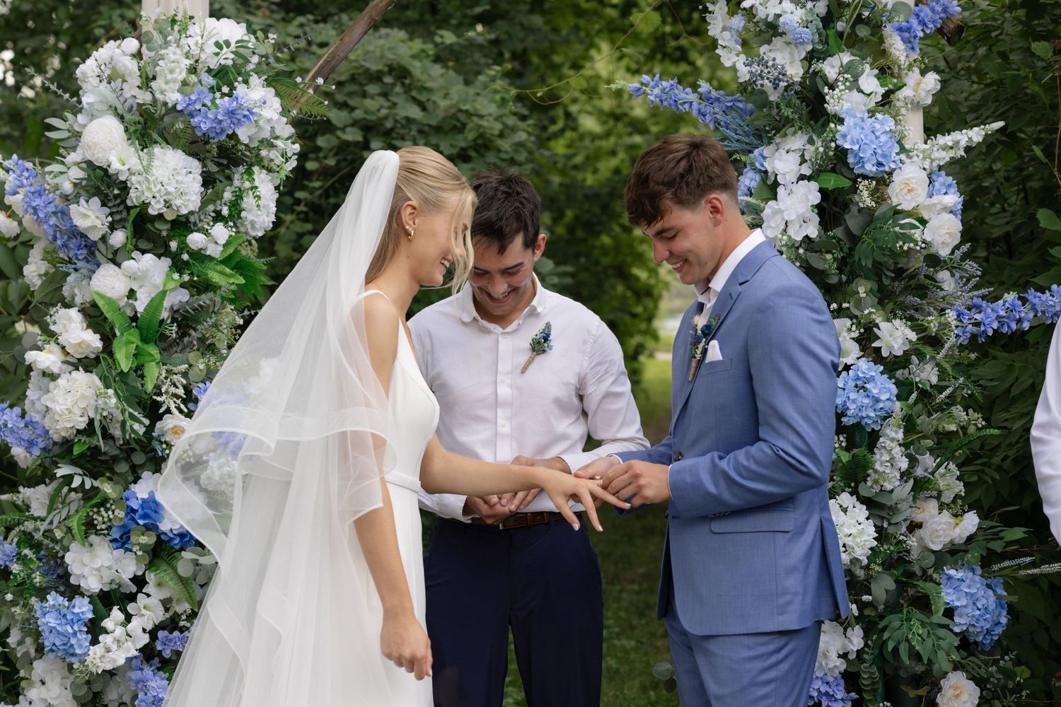 Outdoor wedding ceremony with blue and white floral arrangements.