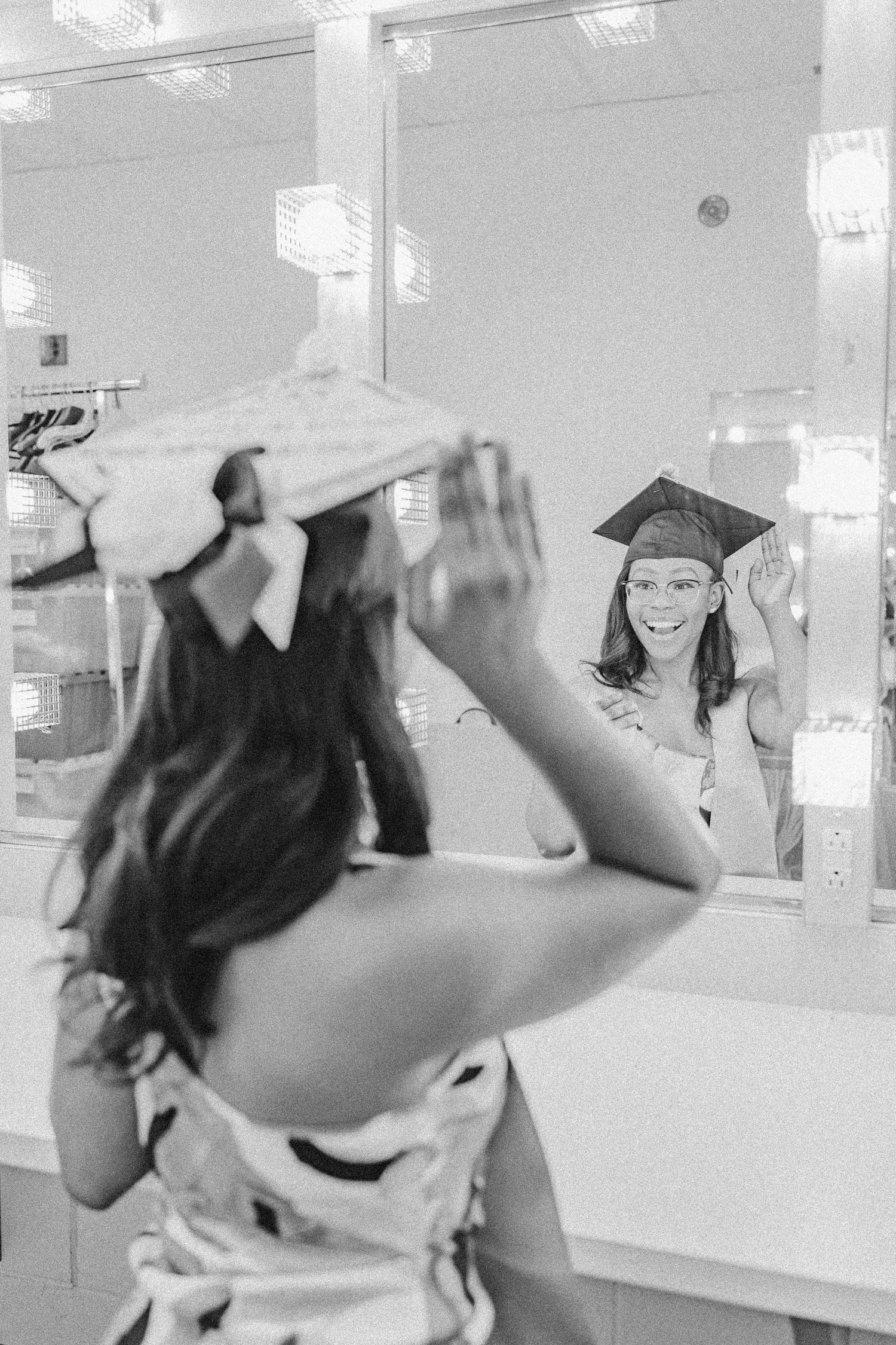 Graduation celebration scene in white room with mirror lights.
