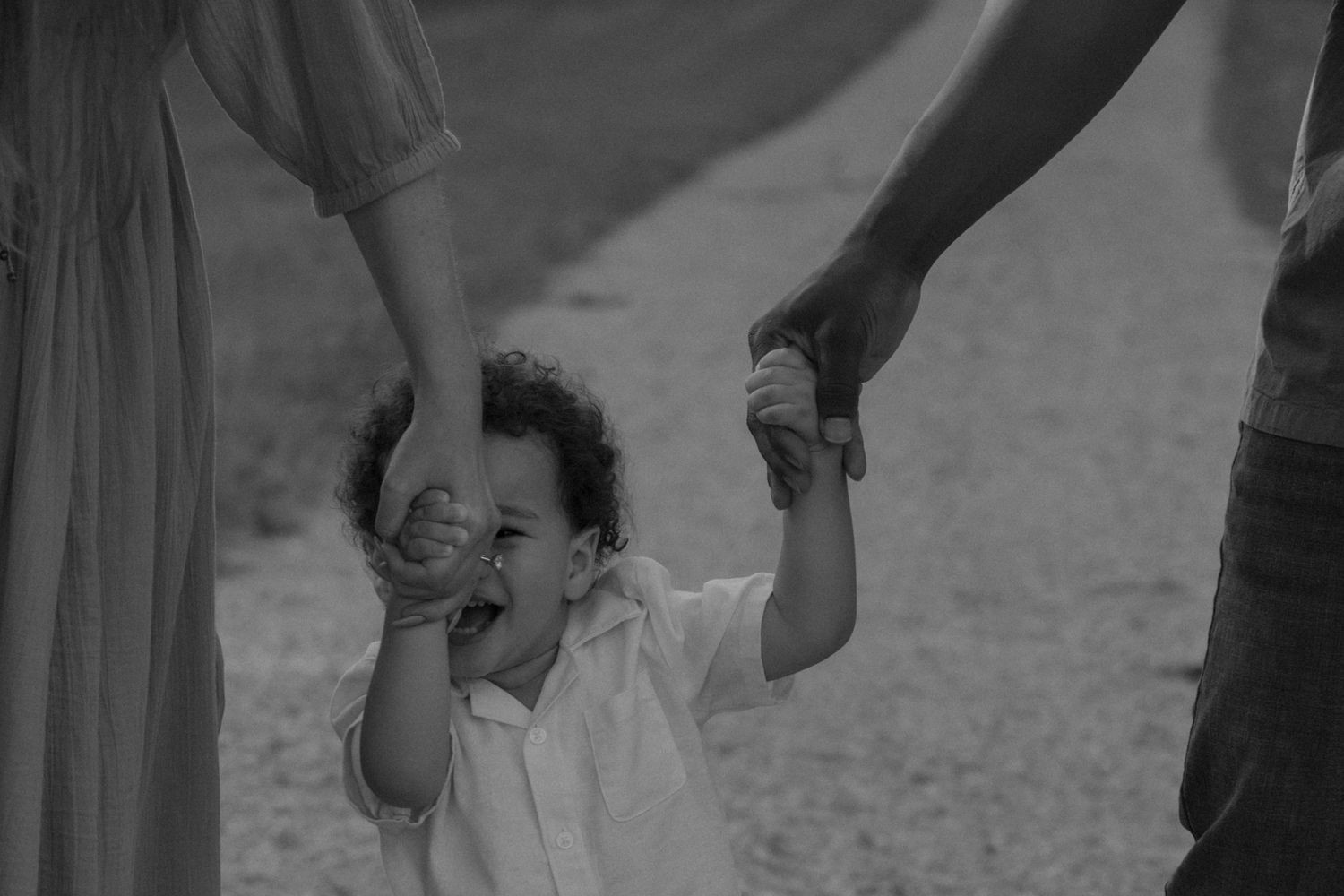 Black and white sequence capturing joyful family moments outdoors.